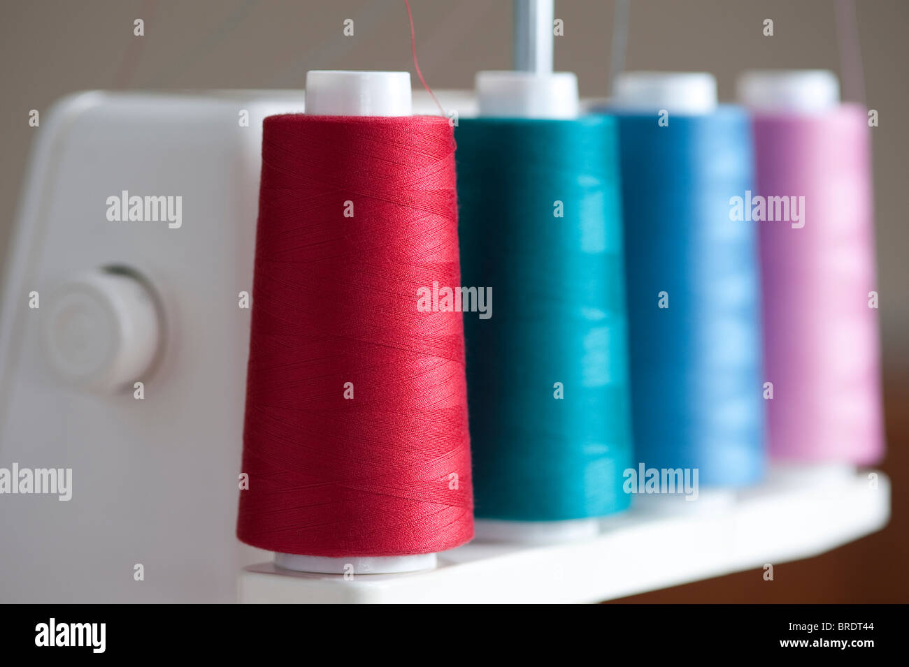 Multicolored spools of thread on a spindle on a serger sewing machine