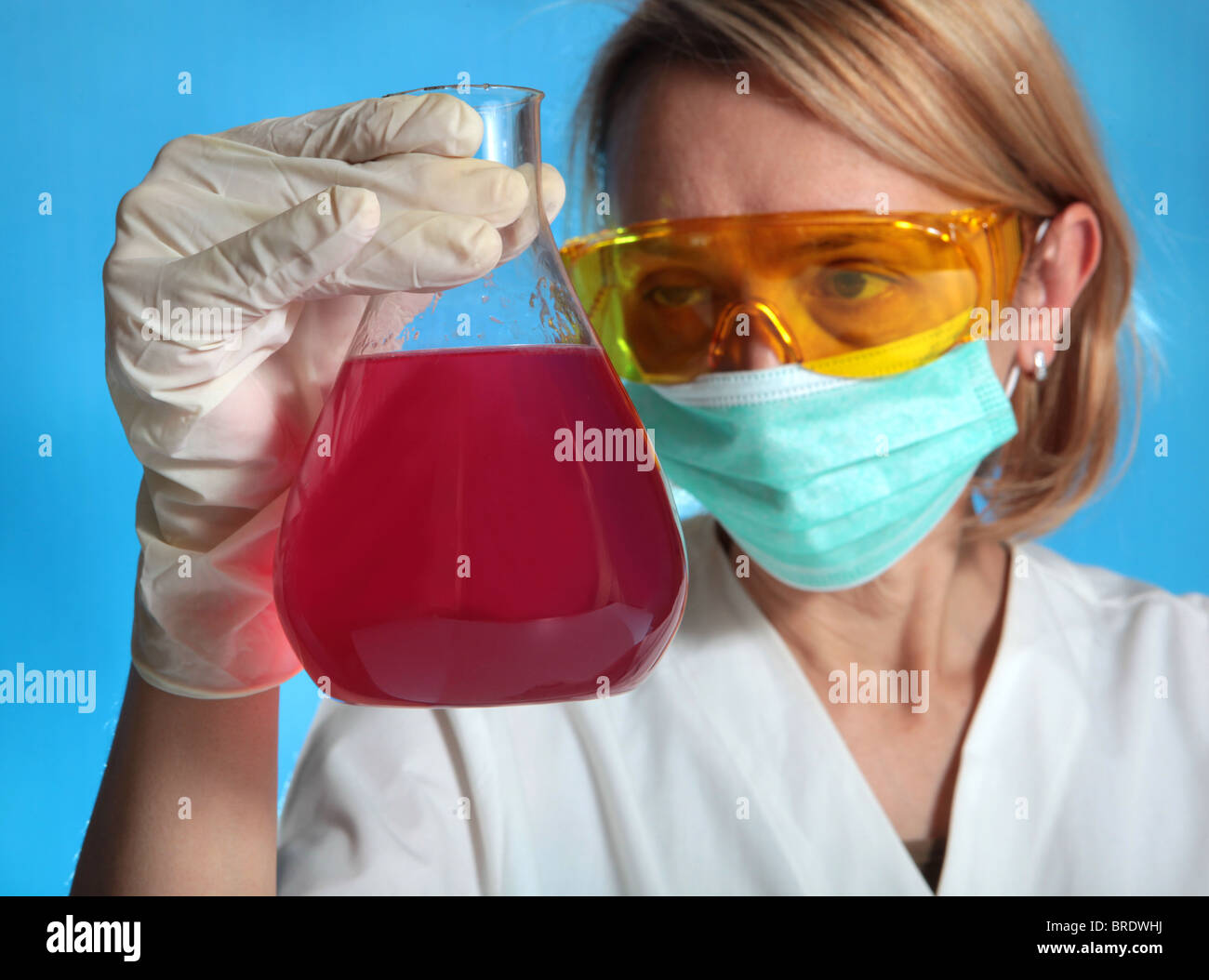 female researcher is analyzing a red liquid Stock Photo