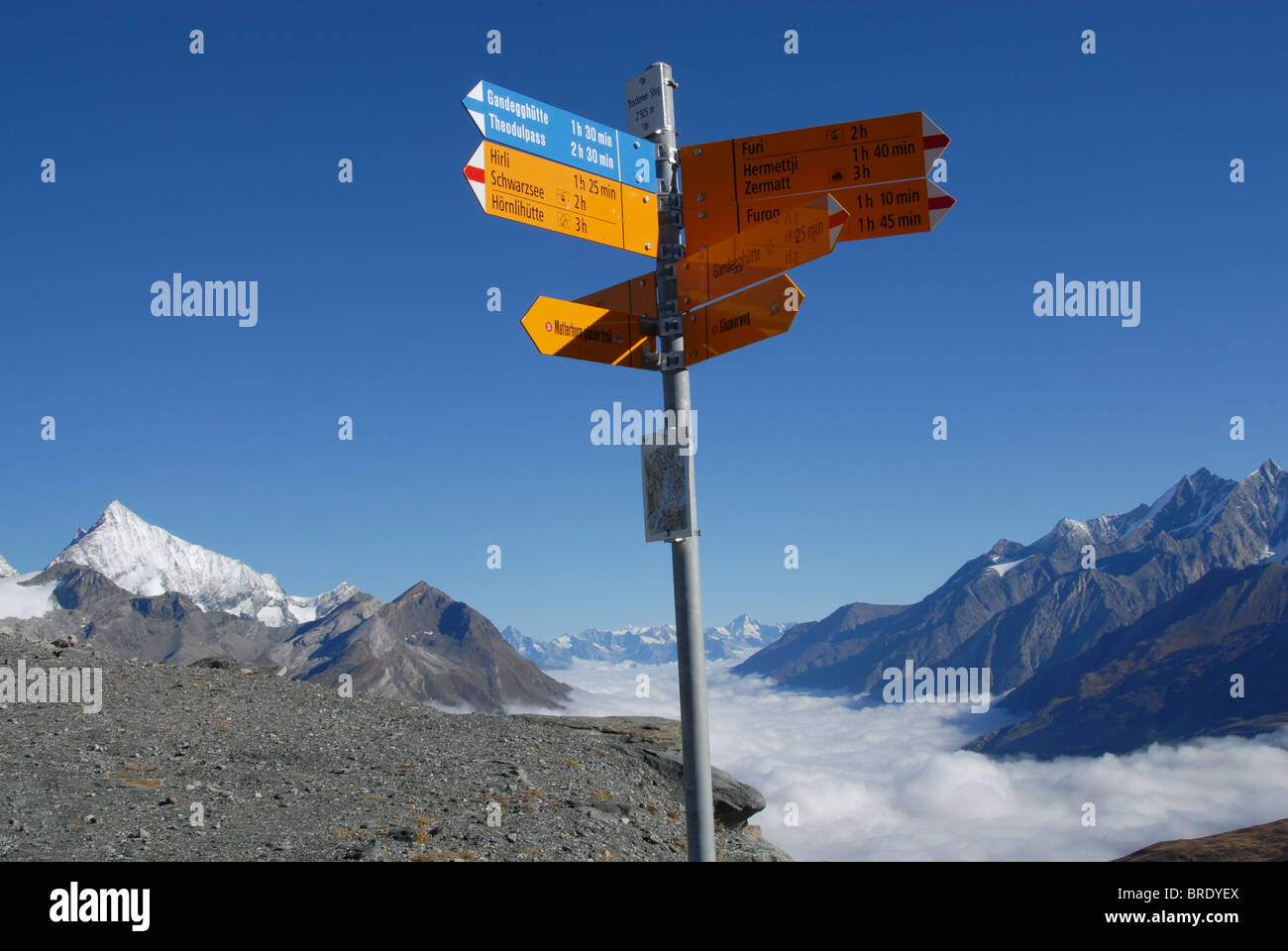 Hiking trail marker at 'Trockener Steg' above Zermatt with fog in valley, Switzerland Stock Photo