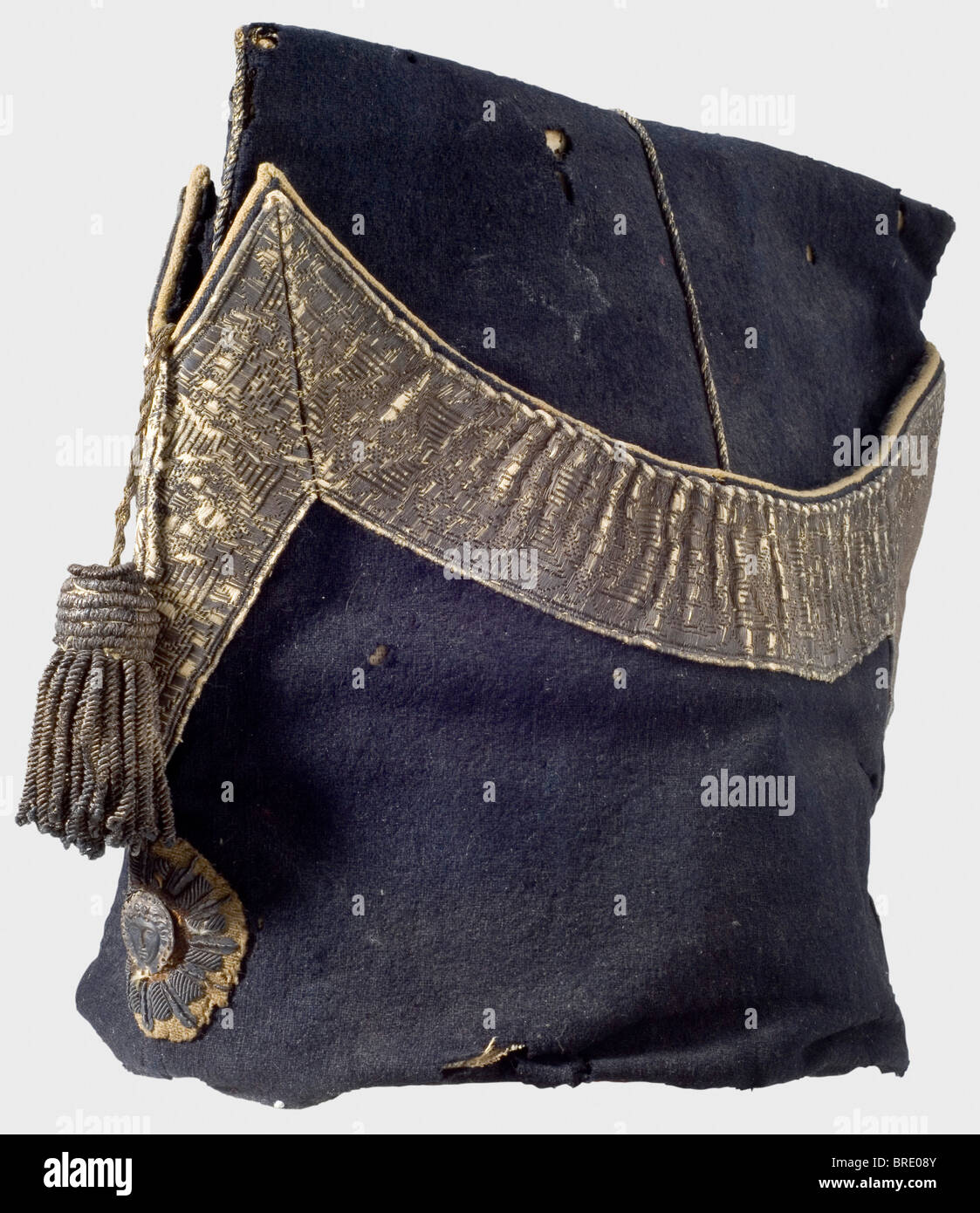 A garrison cap for enlisted men of the Gardes de Corps du Roi, as worn after 1814 Cap of dark blue cloth with silver braid lace, an attached spun silver tassel, and an embroidered emblem bearing the Medusa head. The interior lined with leather, and bearing an old 'Collection André Thélot' label, with the hand-written description, 'Bonnet de Police des Gardes du Corps Compagnie de Luxembourg Maison du Roi 1815'. The cloth shows insect damage in places. The braid is rubbed and darkened. The leather lining shows marks of wear. Height 22 cm. Interesting example of , Stock Photo