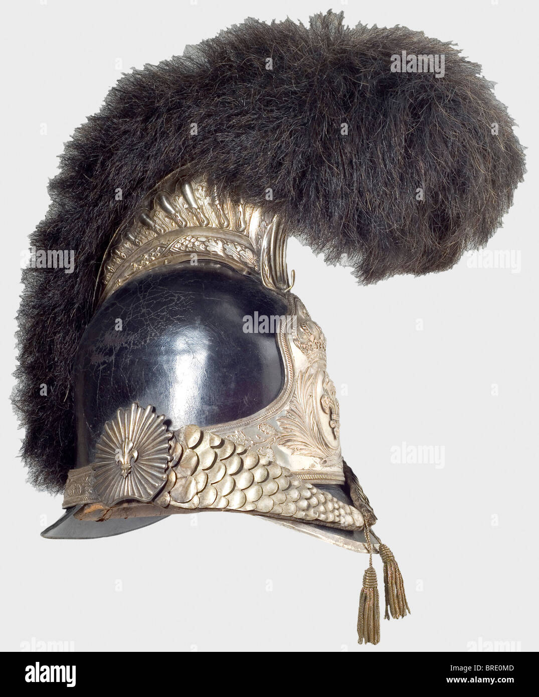 A helmet for the Garde Nationale, Restoration Period A tall two-piece leather skull with silver-plated mountings in fine relief and a horsehair crest. Large plate bearing the Bourbon fleur-de-lys under a crown. Metal chinscales backed with velvet on sunburst rosettes, each with a fleur-de-lys overlay. Leather sweatband and silk lining, marks of age and wear, silver plating rubbed. Height 39 cm. The matching protective case has a light-coloured leather-lined interior, the outside recently refinished with lacquer, and damaged latches. Also a bandolier (not origin, Stock Photo