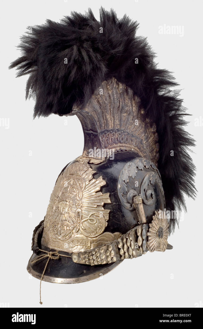 A model 1814 helmet for enlisted men, of the Gardes de Corps du Roi A lacquered leather skull with silver-plated mountings. Tall comb, also silver-plated and bearing fine relief and a black fur crest. Metal chinscales on rosettes with Medusa heads. Feather plume missing. Leather sweatband with silk lining. An illegible owner's name inside the front peak. Silver-plated pieces tarnished. Comb lightly indented on the left side, the leather backing of the chinstrap is torn, and the velvet lining is badly worn. The interior fittings display marks of wear and age. He, Stock Photo