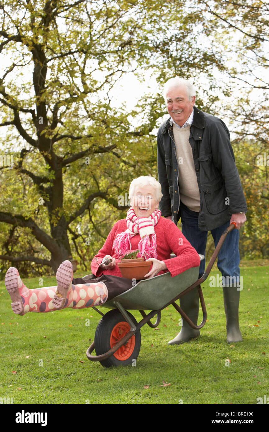 Senior Couple Man Giving Woman Ride In Wheelbarrow Stock Photo