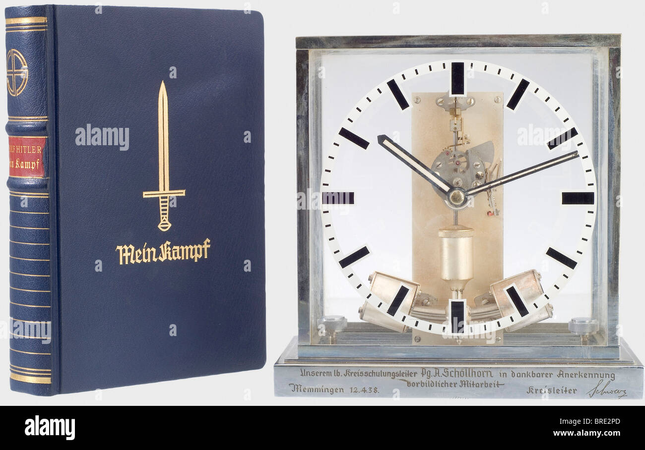 Gauschulungsleiter August Schöllhorn, a presentation clock and jubilee edition of 'Mein Kampf' A table clock with an engraved base: 'Unserm lb. Kreisschulungsleiter Pg. A. Schöllhorn in dankbarer Anerkennung vorbildlicher Mitarbeit - Memmingen 12.4.38 - Kreisleiter Schwarz' (To our beloved Gauschulungsleiter, Party Member August Schöllhorn, in grateful recognition of his exemplary collaboration - Memmingen 12. April.38 - Kreisleiter Schwarz). Silver-plated, unsigned work with a jeweled electrical pendulum movement (the 1.5 volt battery is located behind the car, Stock Photo