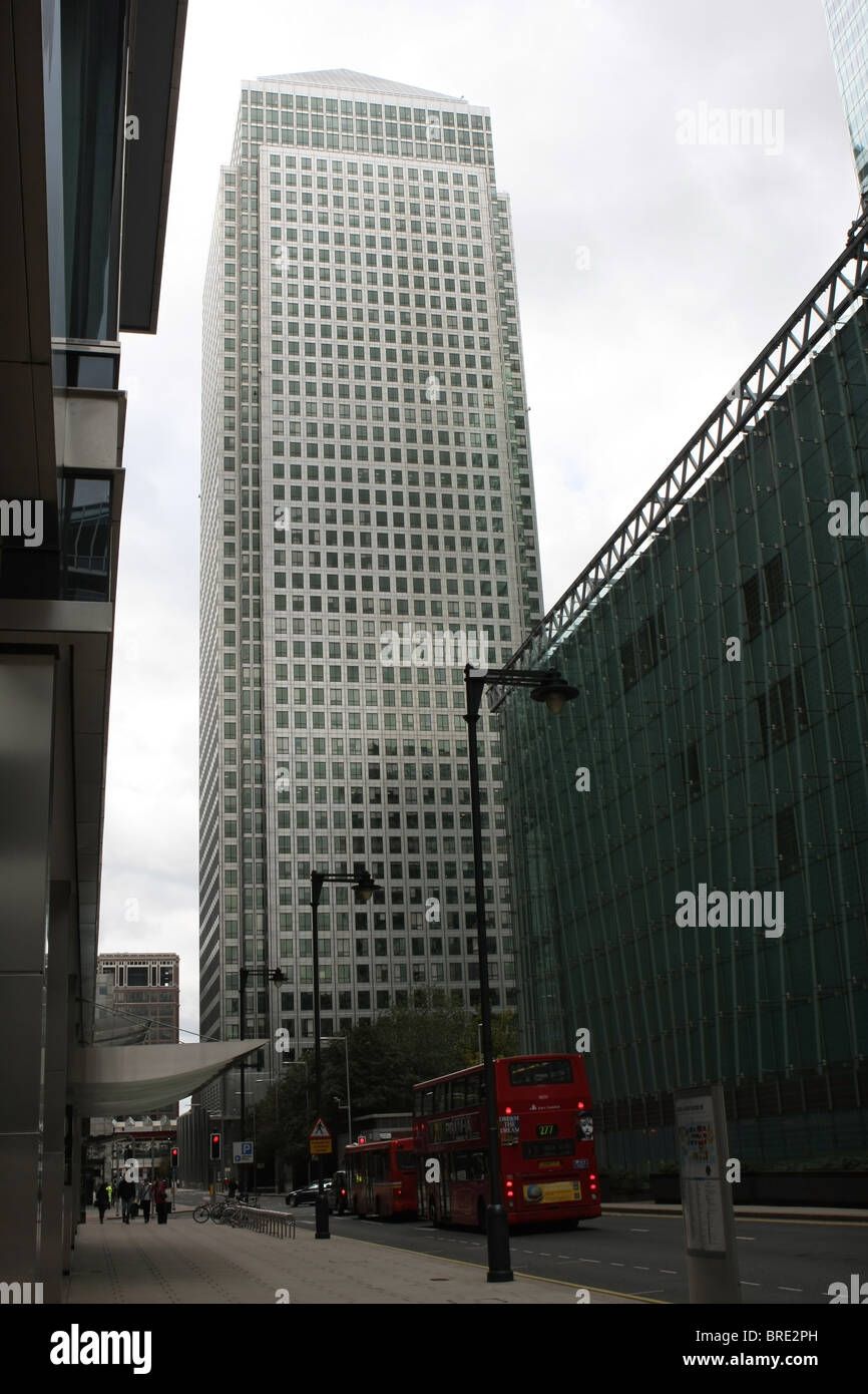 A view of the Canary Wharf building with red London buses passing Stock Photo