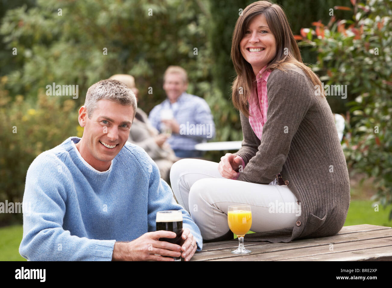 Couple Outdoors Enjoying Drink In Pub Garden Stock Photo