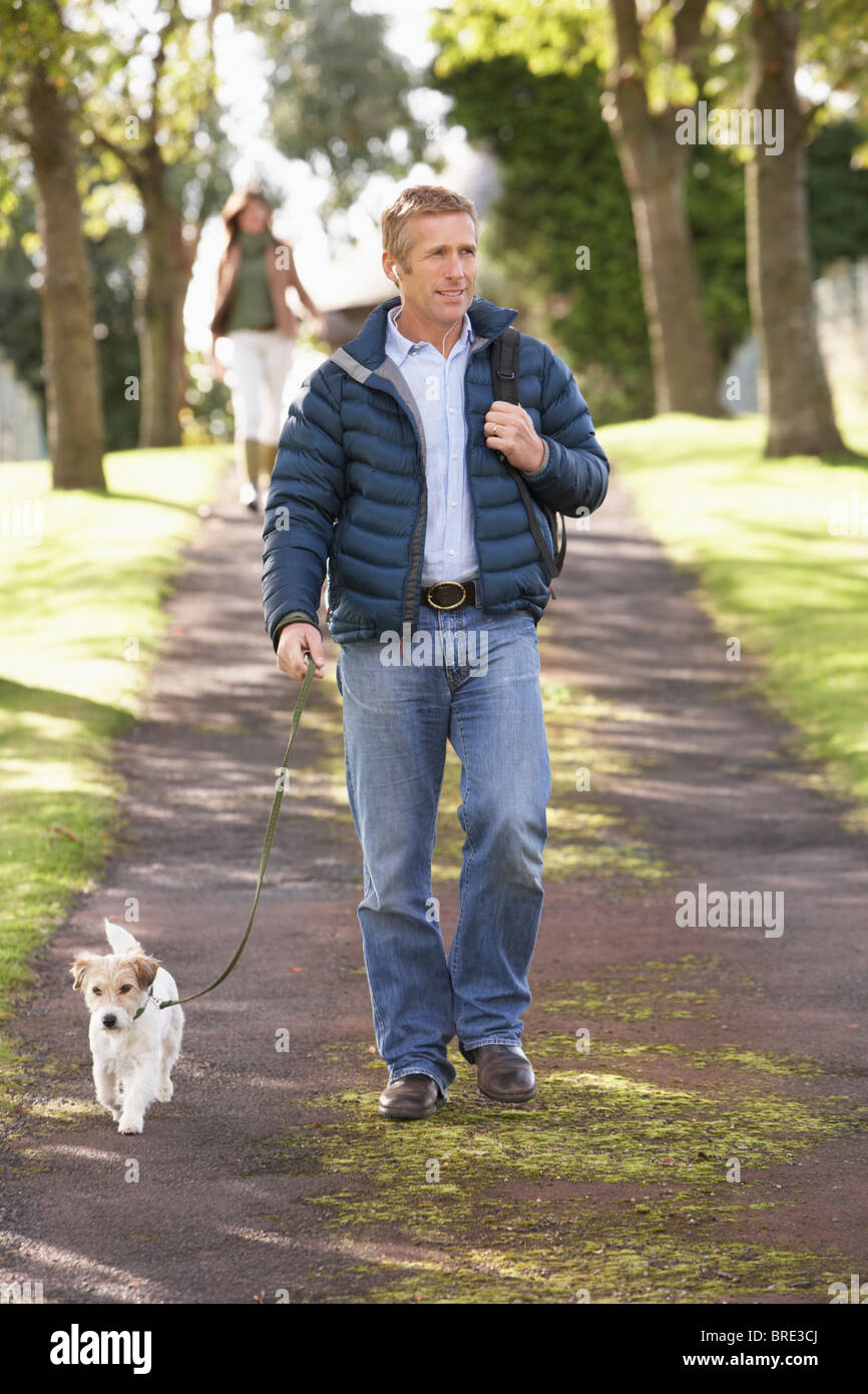 Man Walking Dog Outdoors In Autumn Park Stock Photo
