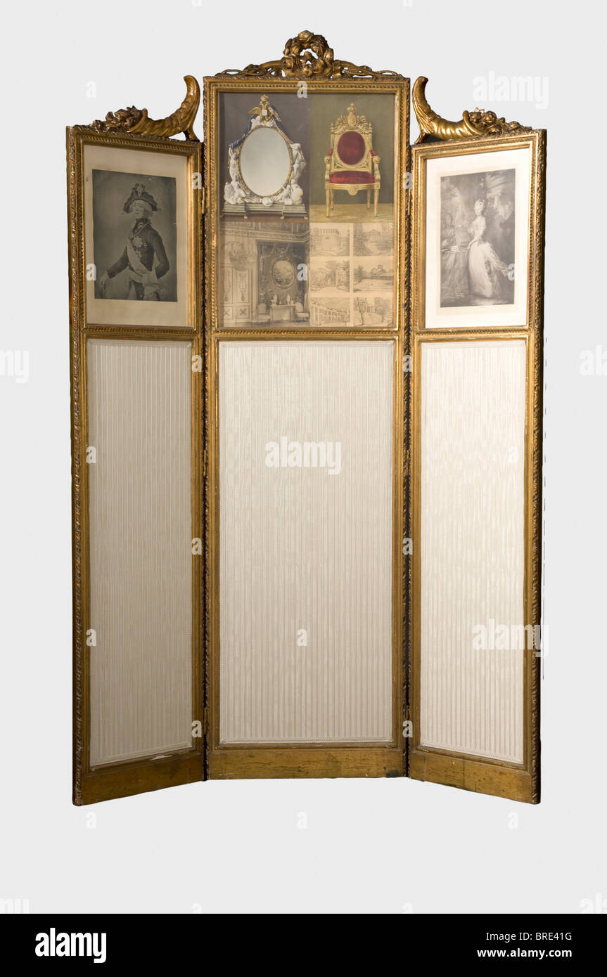 A folding screen, circa 1830. Wood and plaster, gilt. Neo-classic decoration, crowned by a stylised 'O' in the shape of a wreath of roses, and flanked by horns of plenty. The right wing has a damaged inventory label with Olga Nokolaevna's 'ON' and 'H.V.v.W. G.v.R.' for Duchess Vera von Württemberg, Grand Duchess of Russia. Restored in 1910 in plaster, with the old silk panels replaced by velvet/linen and the hinges and two glass panels replaced as well. At that time the original pictures were replaced by printed pictures of Tsar Paul I and his wife Maria Feodor, Stock Photo