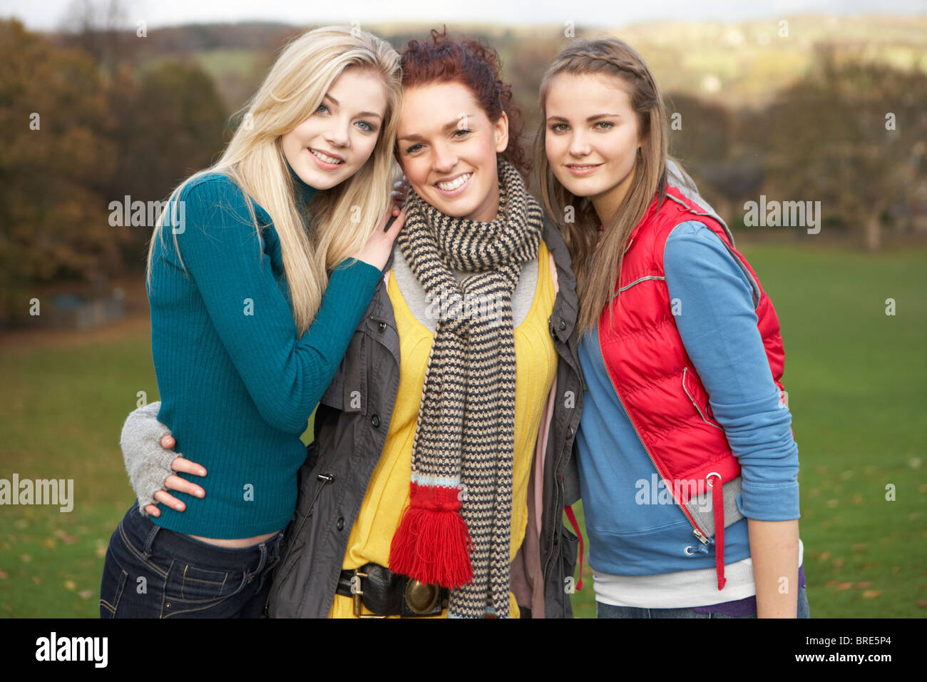 Group Of Three Teenage Female Friends In Autumn Landscape Stock Photo
