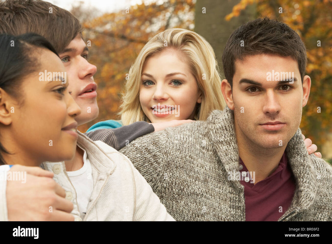 Close Up Of Group Of Four Teenage Friends In Autumn Woodland Stock Photo
