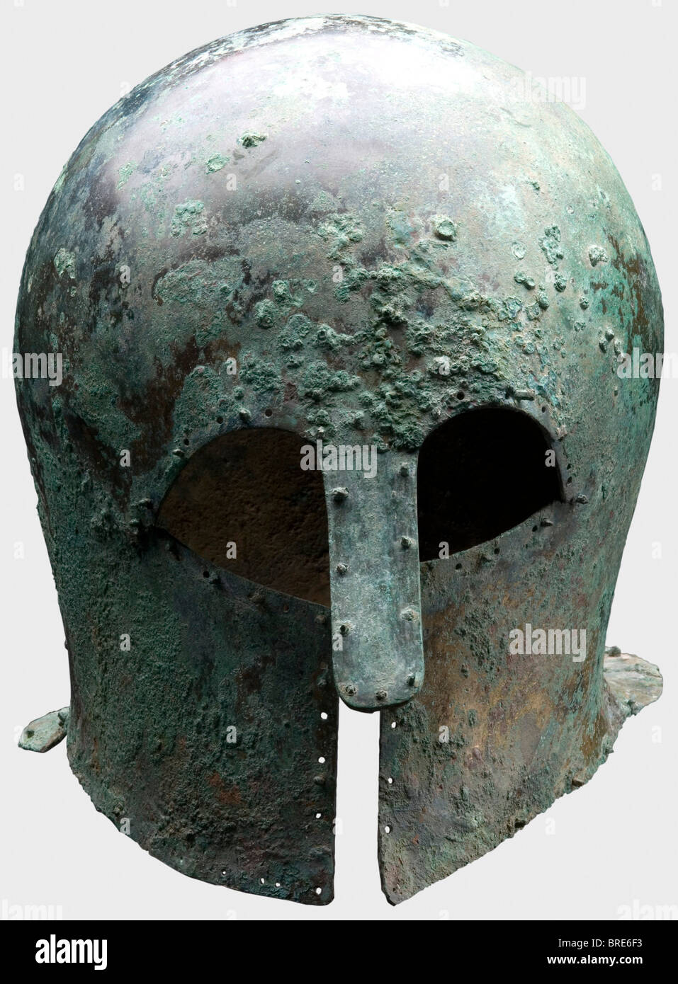 A Corinthian helmet, 7th/6th century B.C. Thick-walled, heavy, bronze Corinthian helmet with a tall skull and extended neck-guard. Large eye cutouts, slightly concave cheekpieces and a sturdy riveted long nose-guard bent outwards. Surrounded with drilled holes, some in pairs, and some still retaining the decorative or lining rivets with round heads. Height 22.1 cm. Weight 1288 g. Metal surfaces with light-brown, dark and light-green patina. Dirt residue inside. Isolated corrosion pits on the surface. Very good metal retention. Axel Guttmann Collection (H 147/ A, Stock Photo