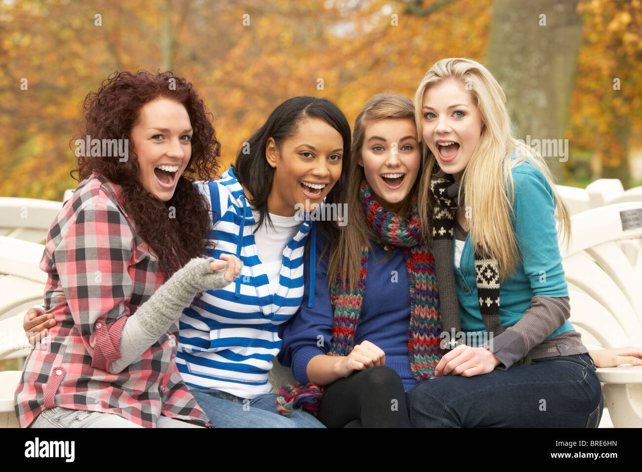 Group Four Teenage Girls Sitting Bench In Autumn Park Stock Alamy
