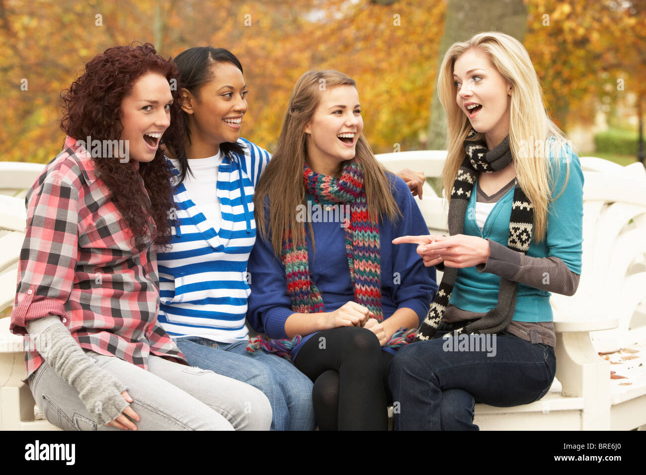 Group Four Teenage Girls Sitting Bench In Autumn Park Stock Alamy