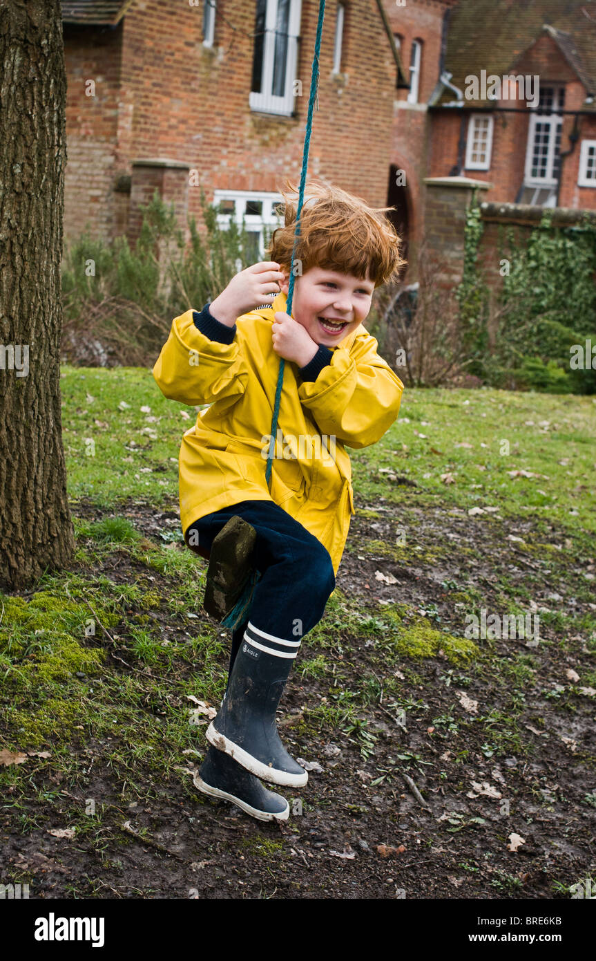 Young boy swinging on a rope swing Stock Photo Alamy