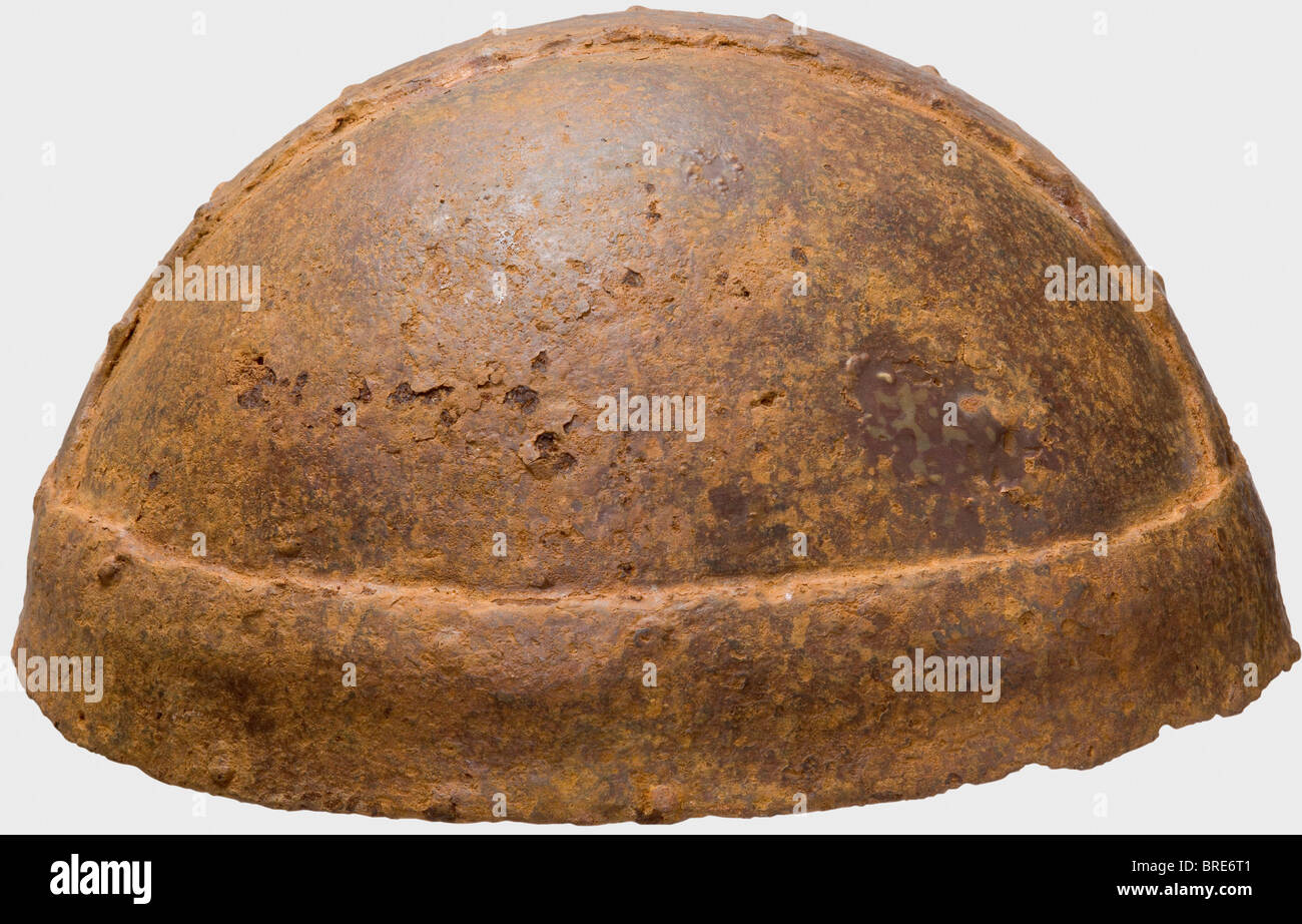 An iron 'Bandhelm', Migration Period, 5th/6th century The skull forged in one piece, fitted with a broad central strap riveted along its rims. A surrounding brow band riveted to the lower edge. Cleaned excavation discovery. Small holes rusted through near the crown. A large crack, ca. 2 cm, on one side has been restored. Height 12.5 cm. historic, historical, ancient world, defensive arms, weapons, arms, weapon, arm, fighting device, object, objects, stills, clipping, clippings, cut out, cut-out, cut-outs, utensil, piece of equipment, utensils, plating, armour-p, Stock Photo