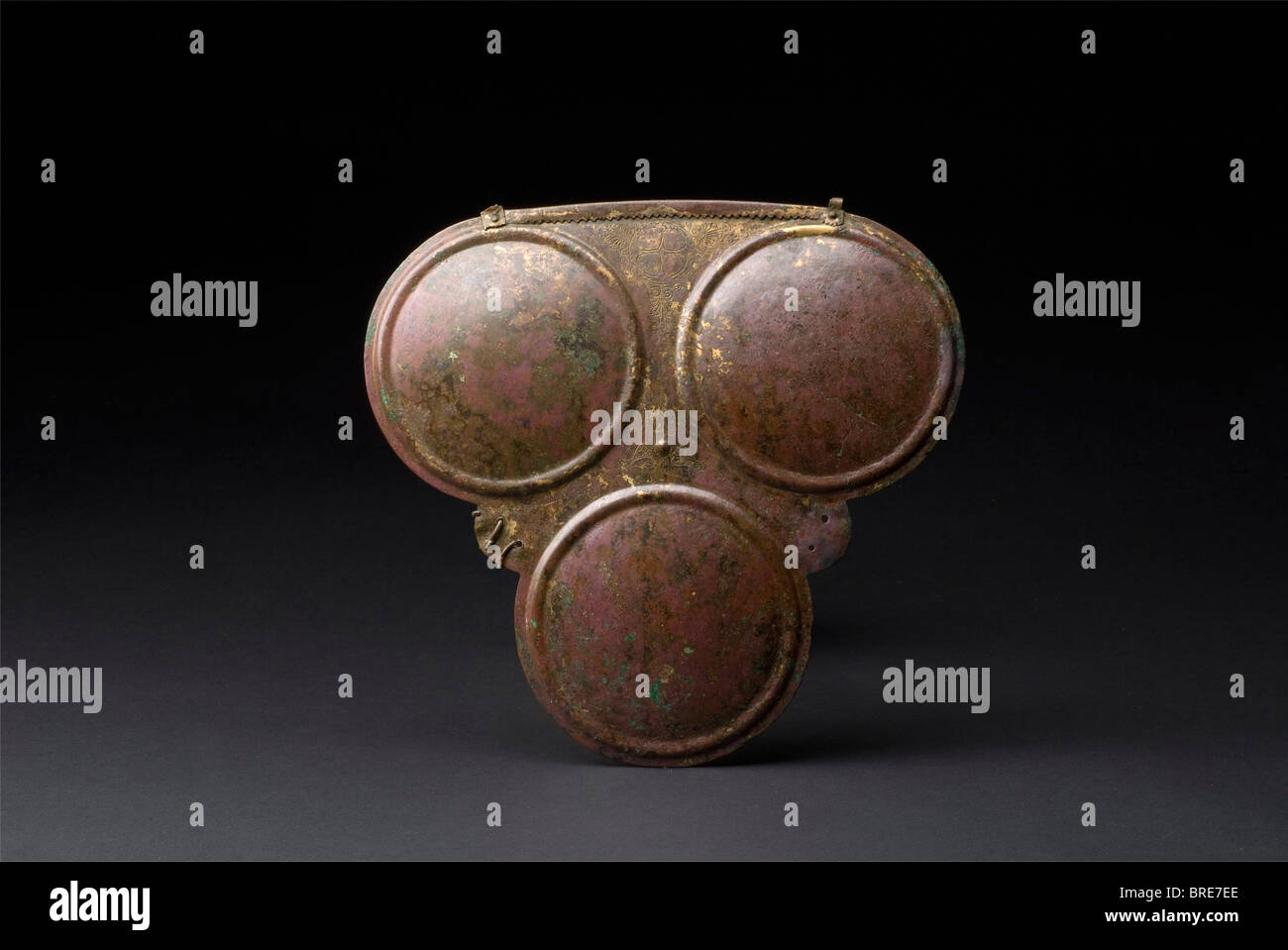 A Samnite triple disc breastplate, 4th century B.C. A bronze breastplate with three large discs, and fine decorative lines of dots and a four-spoke wheel ornament amid palmettes. A small umbo within leaf decoration in the centre of the armour plate. The upper rim is serrated and folded outward, with an attachment (fragments preserved) riveted at the each end for the rings of the shoulder harness. A pair of small holes in the lateral flaps and flaring remnants of the bronze fastenings for the side pieces. Height 24.5 cm. Width 26.2 cm. Wei historic, historical, , Stock Photo