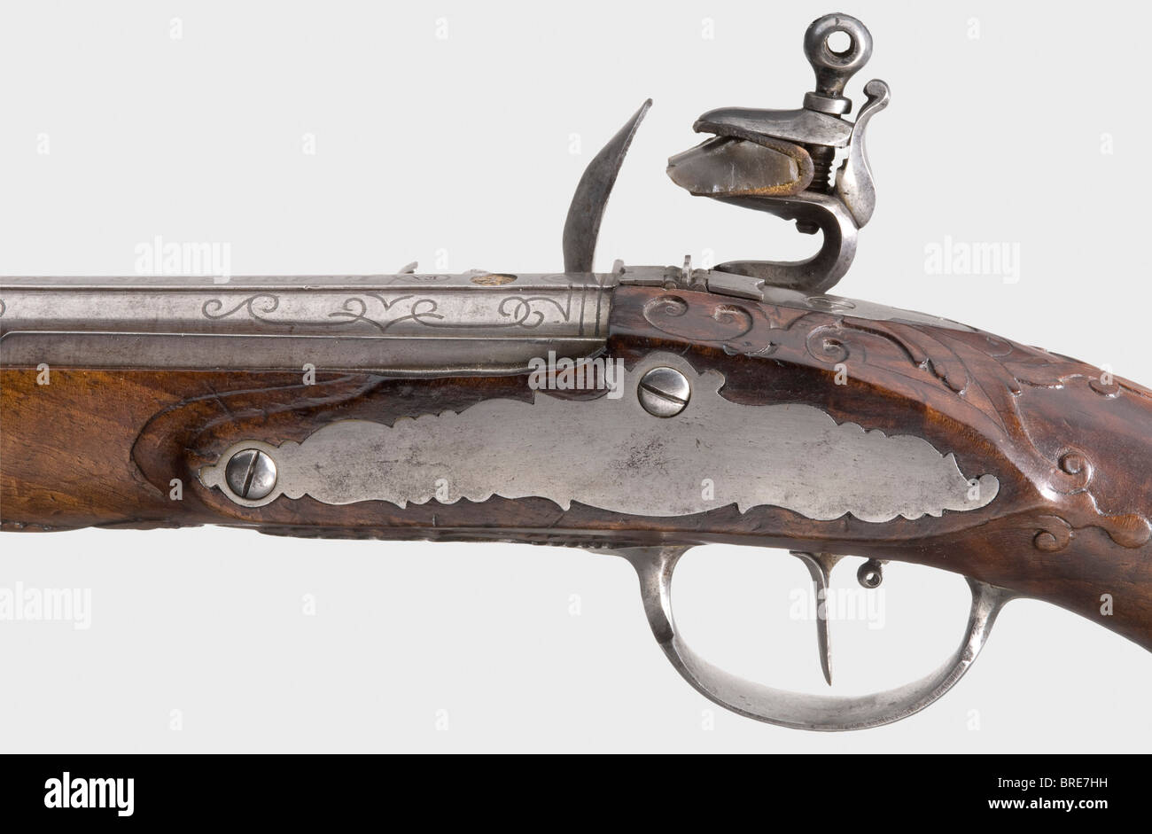 A flintlock pistol, Johann Andreas Kuchenreuter, Steinweg near Regensburg, circa 1800. Round Damascus barrel with microgroove rifling in 12 mm calibre. Silver front sight and folding two-piece iron rear sight. The top of the barrel bears rich silver-inlaid scroll decoration and the signature, 'I. ANDREAS KUCHENREUTER.' The number '2' is inscribed over the breech, which also has a gold-filled rider mark. Iron flintlock with another signature on the lockplate. Roller-mounted frizzen. Single set trigger. Carved walnut stock with a horn nose cap and iron furniture., Stock Photo