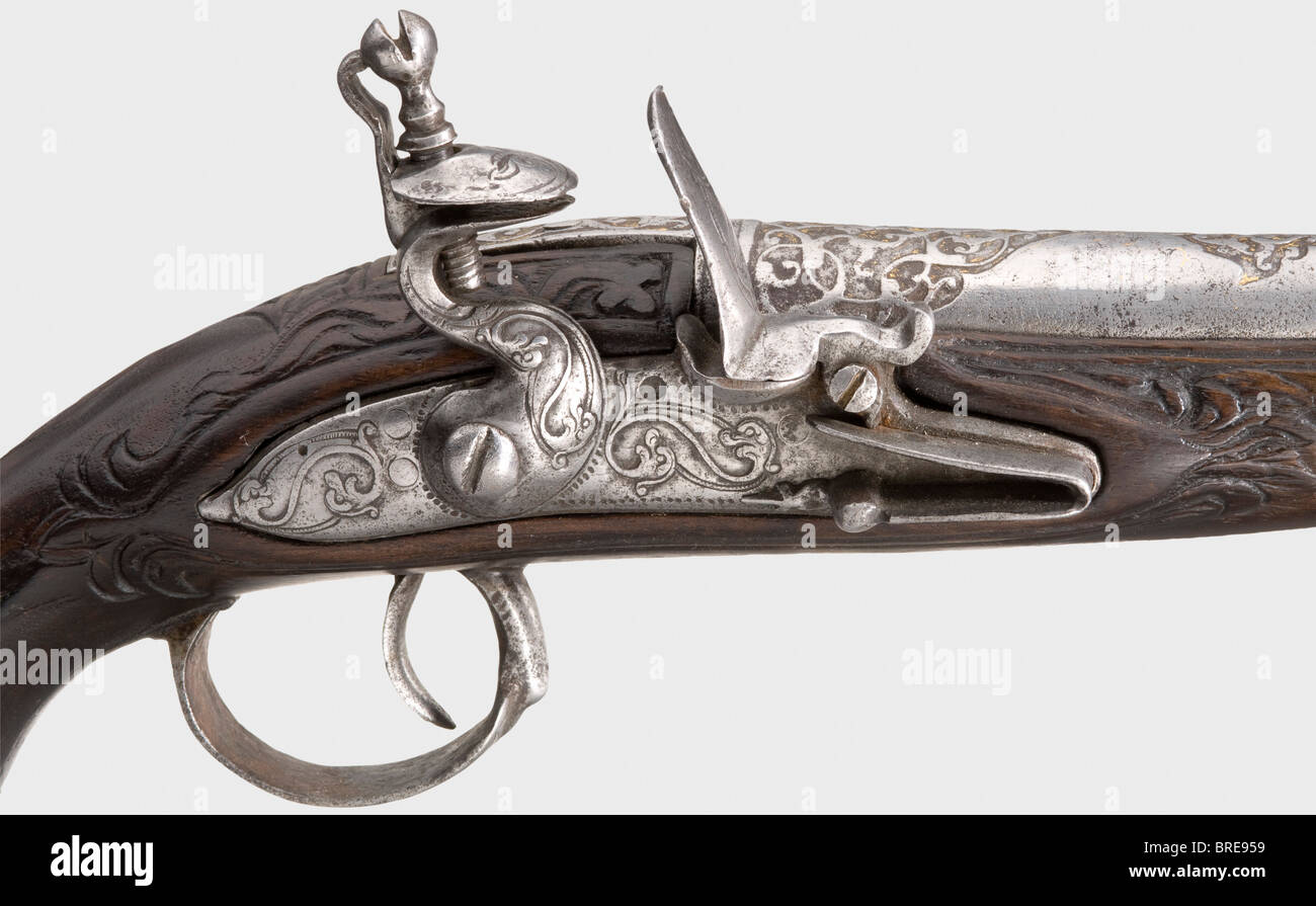 An Ottoman blunderbuss pistol, 18th century Round barrel, widening into a trumpet-shape at the muzzle with remnants of chiselled and gilt ornamental designs on the muzzle and breech. Iron flintlock, cut with intertwined monsters. Carved dark walnut stock with chiselled (somewhat pitted) furniture. Iron pommel ring and short iron ramrod. Length 47 cm. historic, historical, 18th century, Ottoman Empire, handgun, handheld, firearm, fire arm, gun, fire arms, firearms, guns, weapon, arms, weapons, arms, pistols, object, objects, stills, clipping, clippings, cut out,, Stock Photo