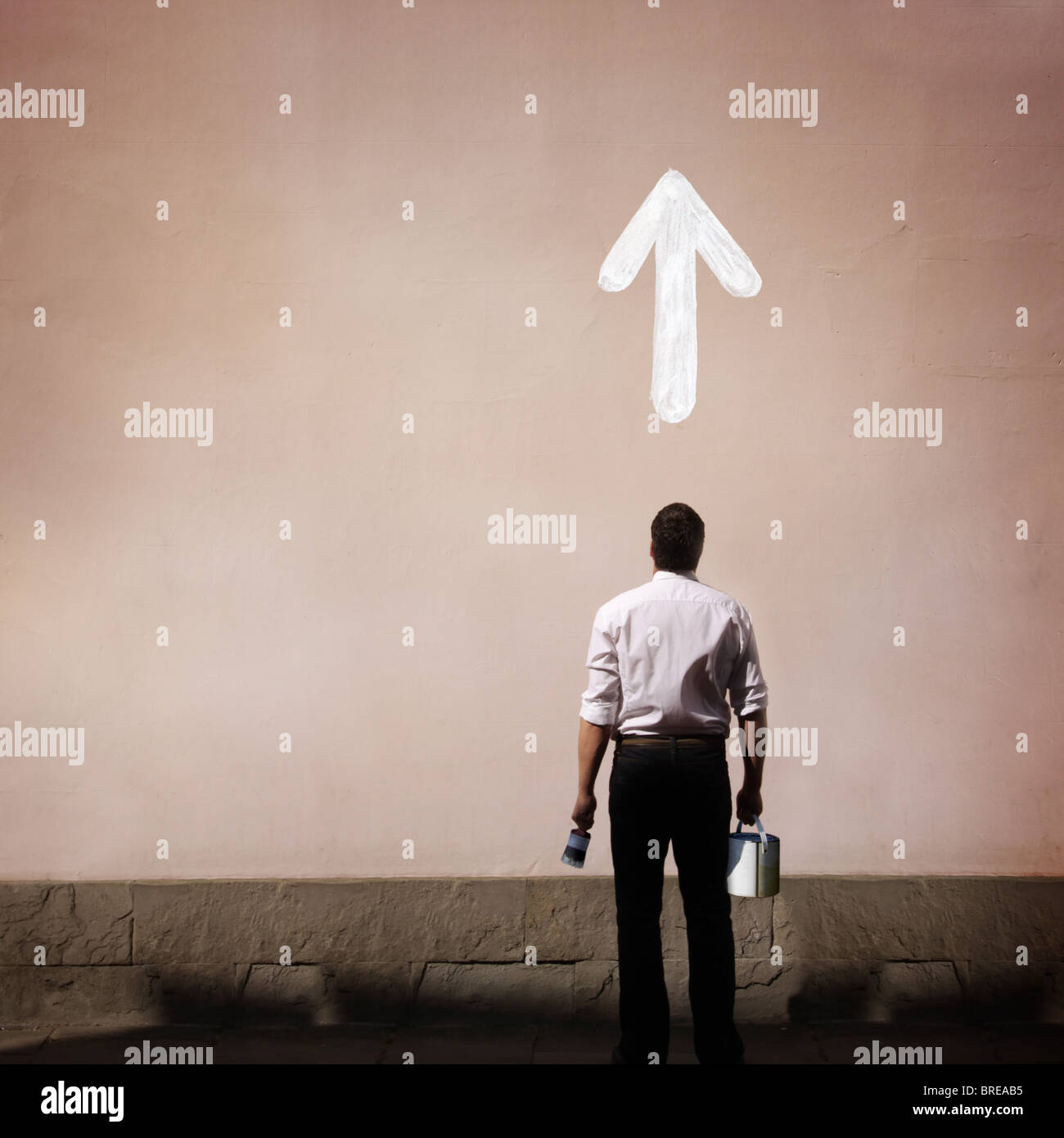 man with arrow painted on the wall Stock Photo