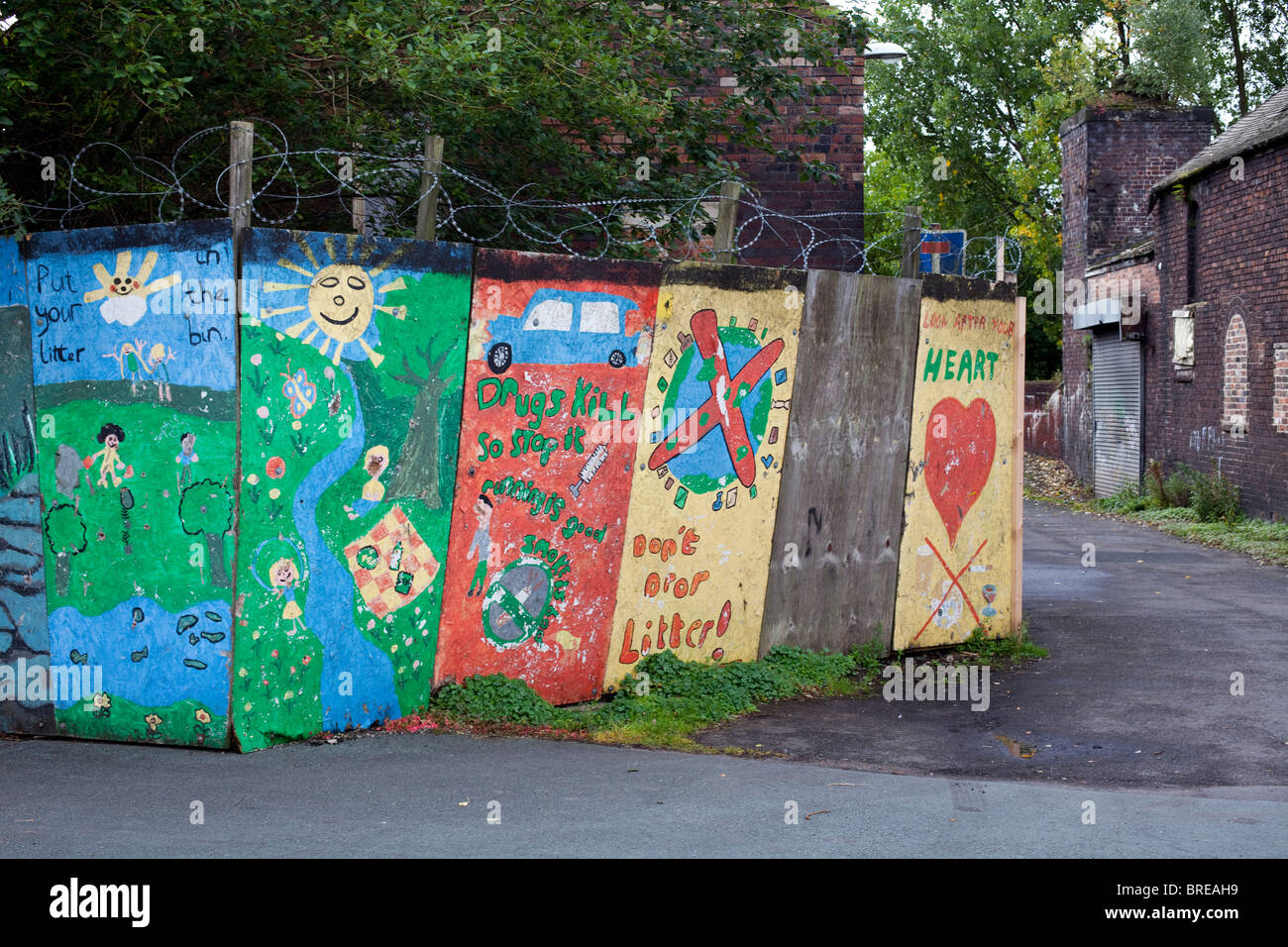 Colourful positive slogans and messages painted by young people on wooden panels in a run down area of Stoke-On-Trent, UK Stock Photo