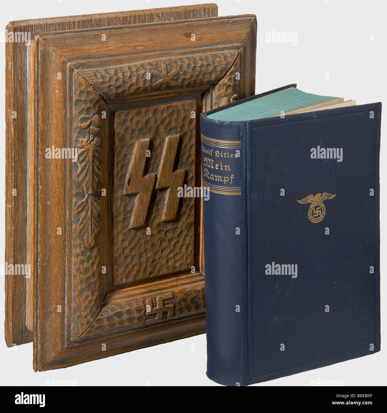 A wooden SS-presentation case, for 'Mein Kampf' Oak, with a darkly stained exterior. The lid (two internal mouldings missing/restored) has the SS runes carved in the centre, surrounded by a knotty raised circle with the swastika and oak leaves. Dimensions 25.5 x 19.5 x 8 cm. Inside is the unabridged 1934 edition with the blue cloth binding. historic, historical, 1930s, 20th century, Waffen-SS, armed division of the SS, armed service, armed services, NS, National Socialism, Nazism, Third Reich, German Reich, Germany, military, militaria, utensil, piece of equipm, Stock Photo