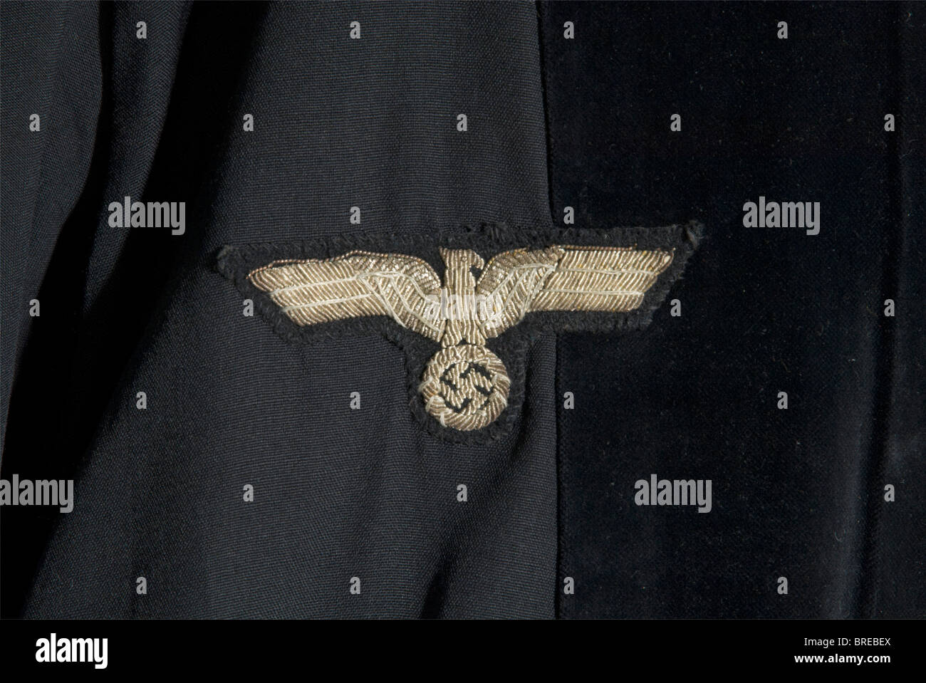 An official robe, for a judge or prosecutor Black cotton with velvet trim and a party eagle embroidered in silver on the right side of the chest. Black covered buttons. A cloth label sewn in, 'Amtstrachten (official robes) Hermann Beck, Berlin S. 42 Dresdenerstr. 127'. Worn, a few mendings. historic, historical, 1930s, 1930s, 20th century, uniform, uniforms, piece of clothing, clothes, outfit, outfits, Stock Photo