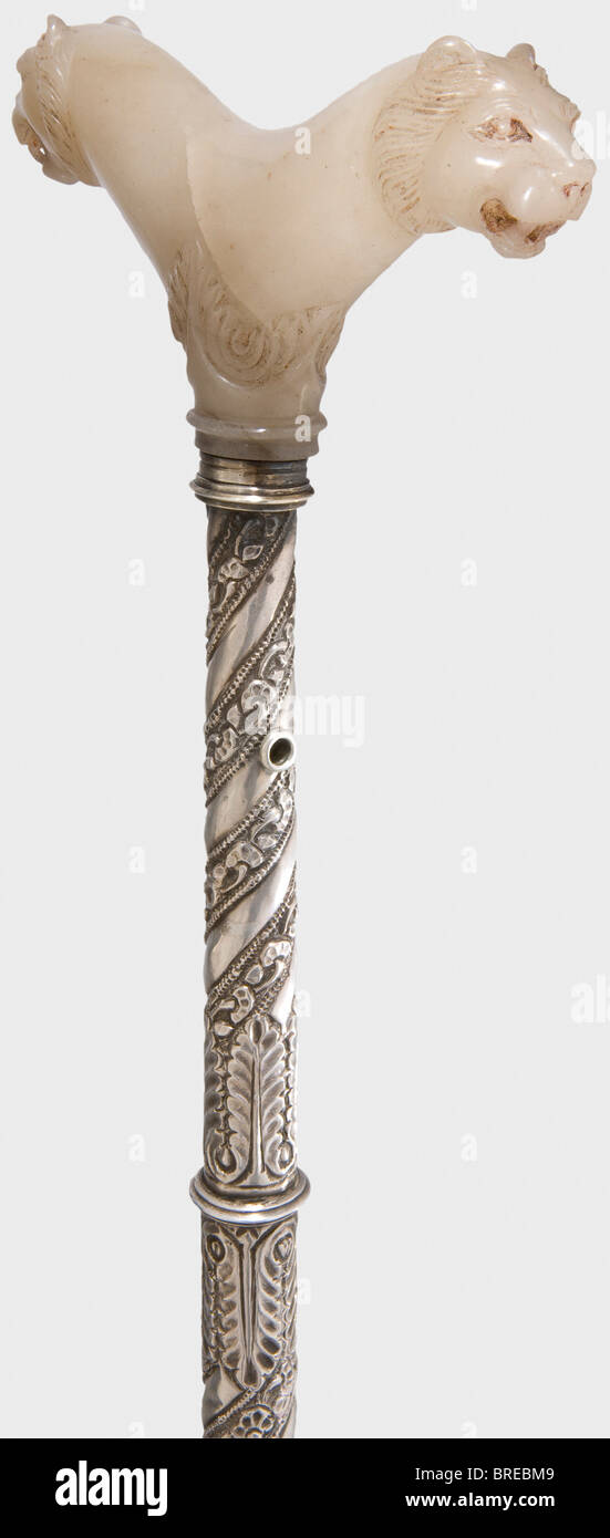 An Indian crutch with a cut jade handle, 17th/18th century One-piece, light grey jade handle with two sculpted lion heads on the sides on a base with cut floral designs. The (somewhat later) tapering silver shaft is surrounded with a spiral pattern of embossed floral decoration and has a spherical pommel. Length 61 cm historic, historical, 18th century, object, objects, stills, clipping, clippings, cut out, cut-out, cut-outs, fine arts, art, artful, Stock Photo