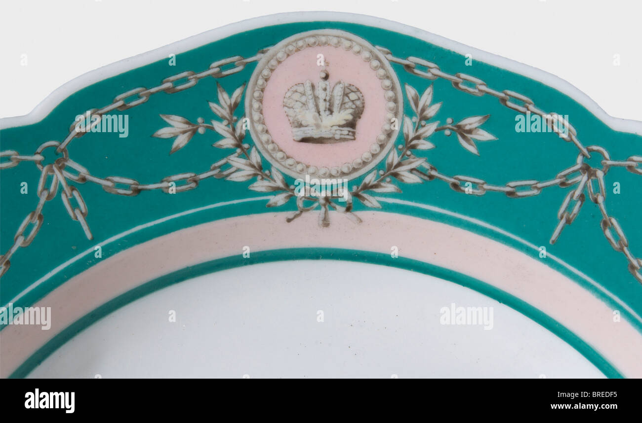 A soup plate from Tsar Alexander II's yacht service, Imperial Russian Porcelain Manufactory St. Petersburg White, glazed porcelain, with hand-painted decoration in green and light rose colour. The border displays an imperial Russian crown in a cartouche. The underglaze green manufacturer's mark, "A II", is on the bottom. Hairline crack. Diameter 26 cm. Provenance: Grand Duchess Olga Nikolaevna Romanova (1822 - 1892). historic, historical, 19th century, dishes, dish, plate, plates, object, objects, stills, clipping, clippings, cut out, cut-out, cut-outs, Stock Photo