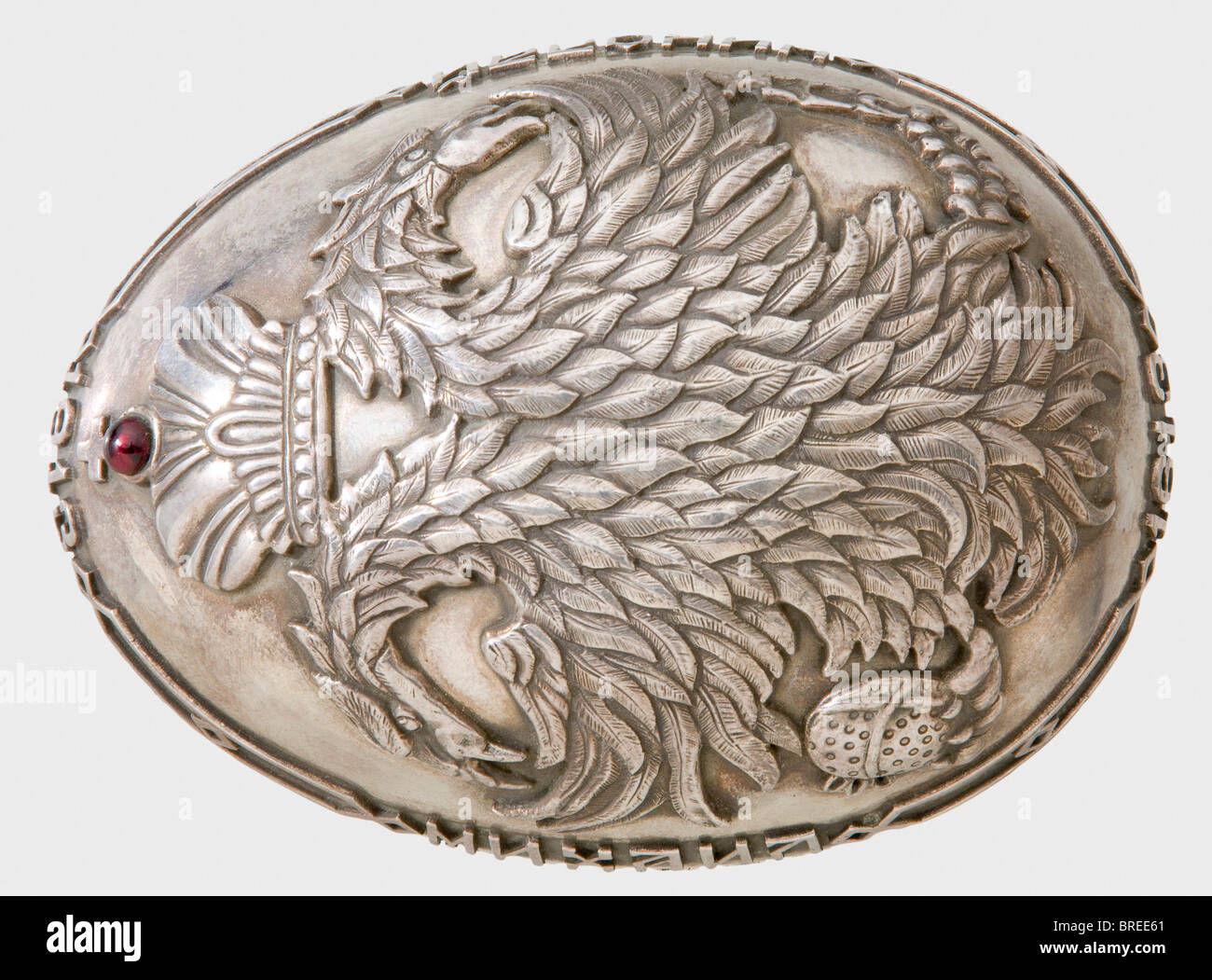 A silver egg, gift from the House of Romanov, on the occasion of their 300th anniversary, 1913 Purveyor to the Court, Pavel Ovchinnikov, Moscow, 1913. Silver, gilt interior, made in two pieces. Raised double-headed eagle beneath the tsarist crown adorned with a red almandine. Surrounding inscriptions 'Mihail 1613 - Nikolai 1913' and '300 Years'. Cyrillic master's mark, 'Ovchinnikov' with the double-headed eagle, and Moscow hallmark for '84' zolotniki. Oval silver stand with three pine feet. Dimensions ca 12.5 x 9 cm. Total height 10 cm. Total weight 593 g. hist, Stock Photo