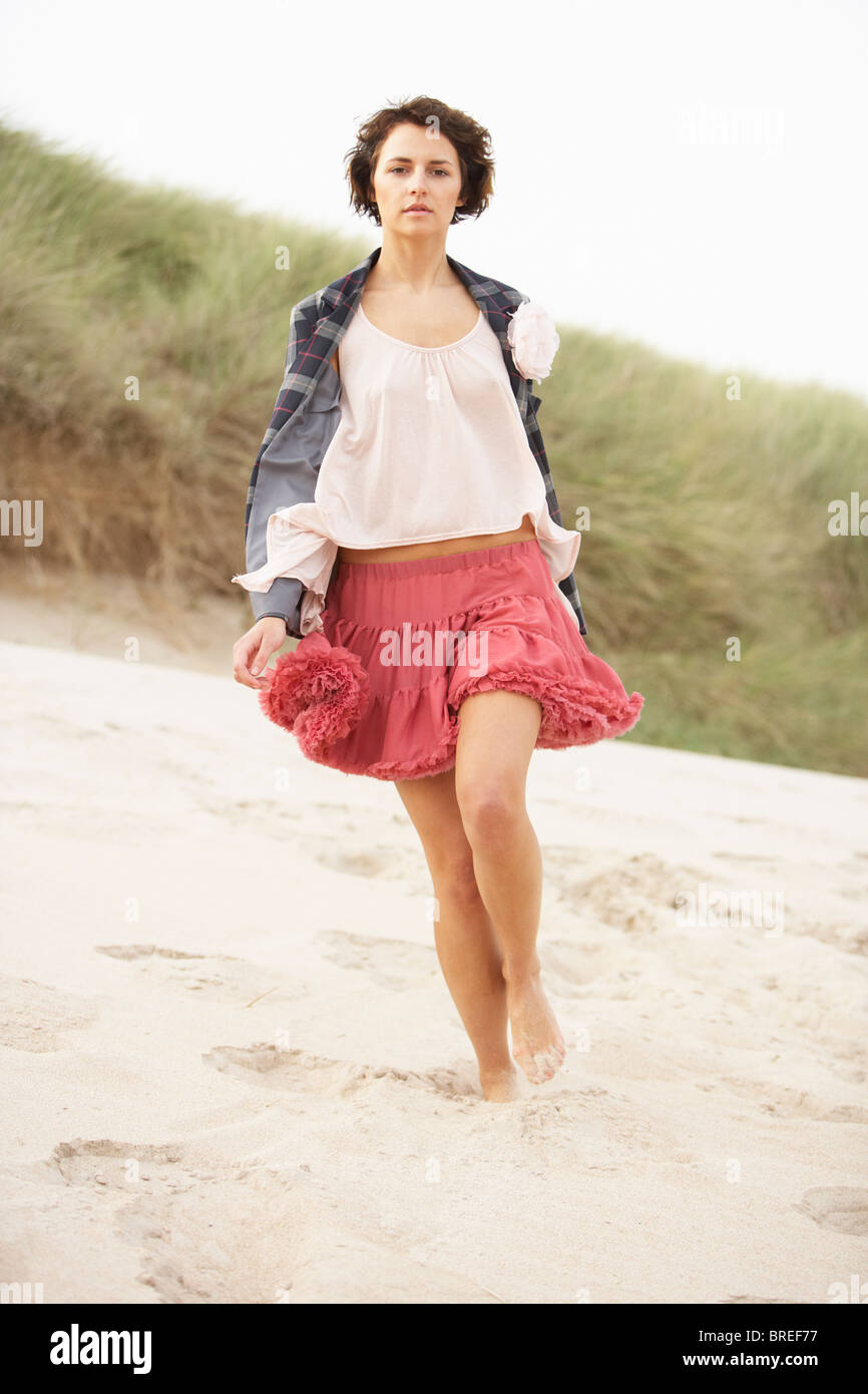 Fashionably Dressed Attractive Young Woman Standing Amongst Sand Dunes Stock Photo