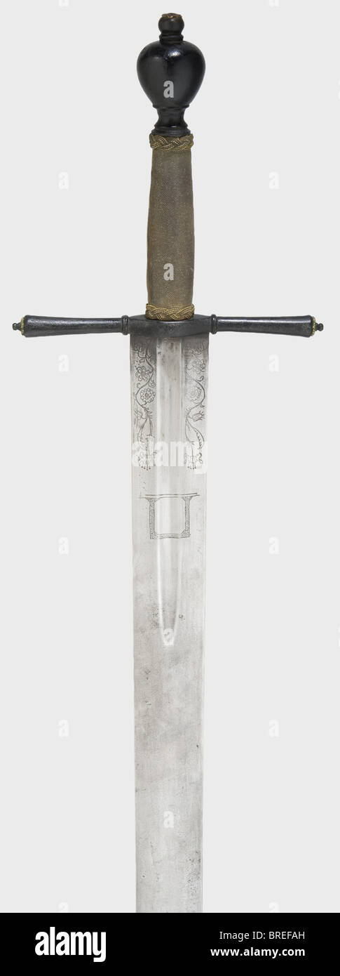 A German executioner's sword, ca. 1700 Broad blade, blunt point with three holes, the forte with fuller. Decorative etching at the base of the blade on both sides, portraying a gallows and wheel between scrolling flowers, the etching probably added in the 19th century. Blackened cross-guard with slightly conical, round quillons, the ends decorated with brass rosettes. Fish skin covered grip with Turk's head ferrules made of brass. Heavy, blackened pommel. Length 110 cm. historic, historical, 18th century, instrument of torture, torture device, instruments of to, Stock Photo