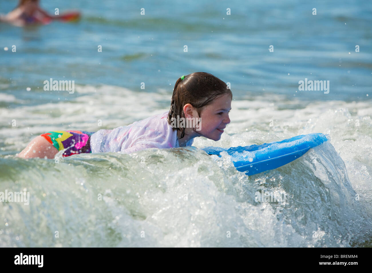 Young girl bodyboarding and enjoying the surf at Newgale beach in