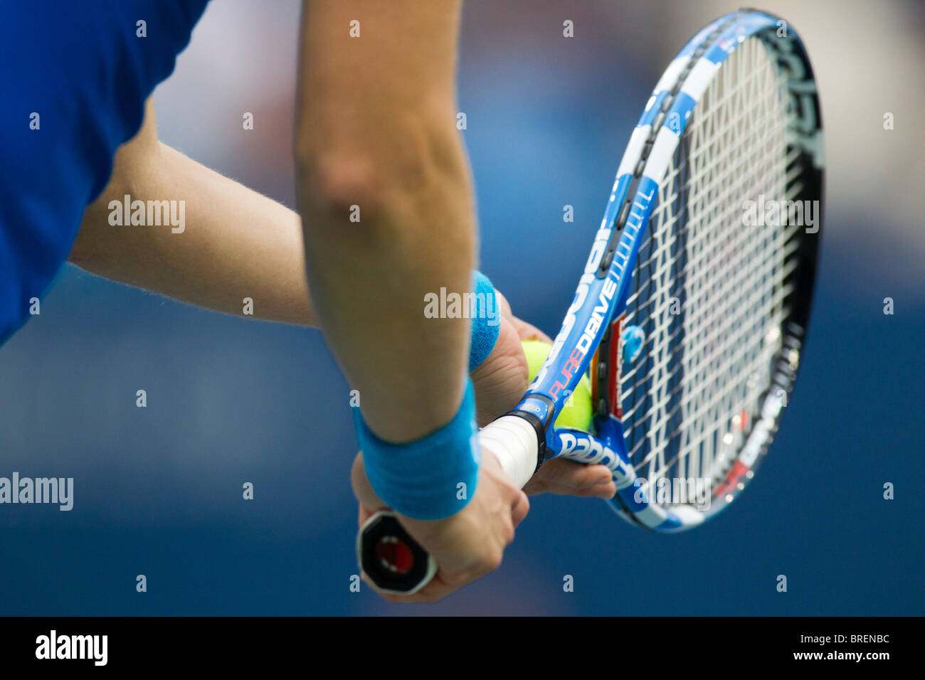 Detail of tennis player holding the racquet and ball about to serve