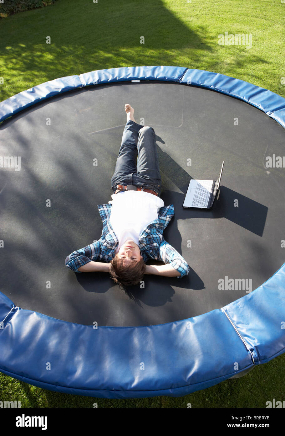 lede efter ortodoks Derfor Young Man Relaxing On Trampoline With Laptop Stock Photo - Alamy