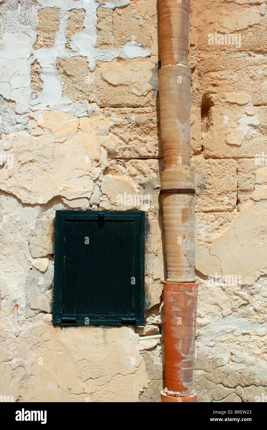 Mediterranean style downpipes on the side of a wall Stock Photo