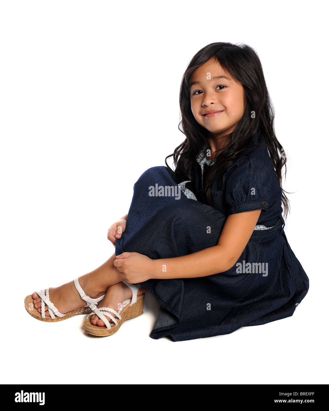 Portrait of young Asian girl sitting isolated over white background Stock Photo