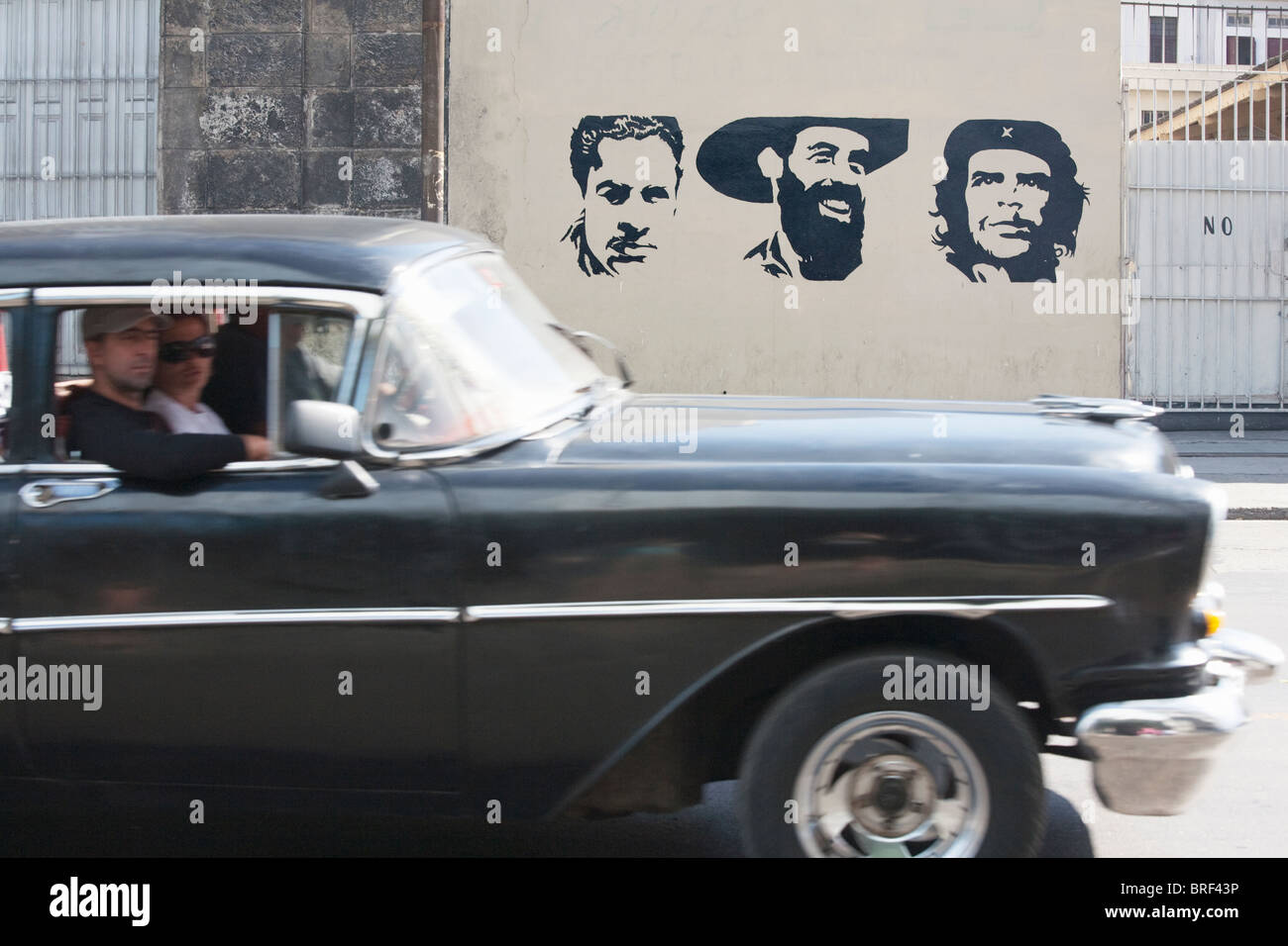 HAVANA: COMMUNIST GRAFFITI AND VINTAGE CAR Stock Photo