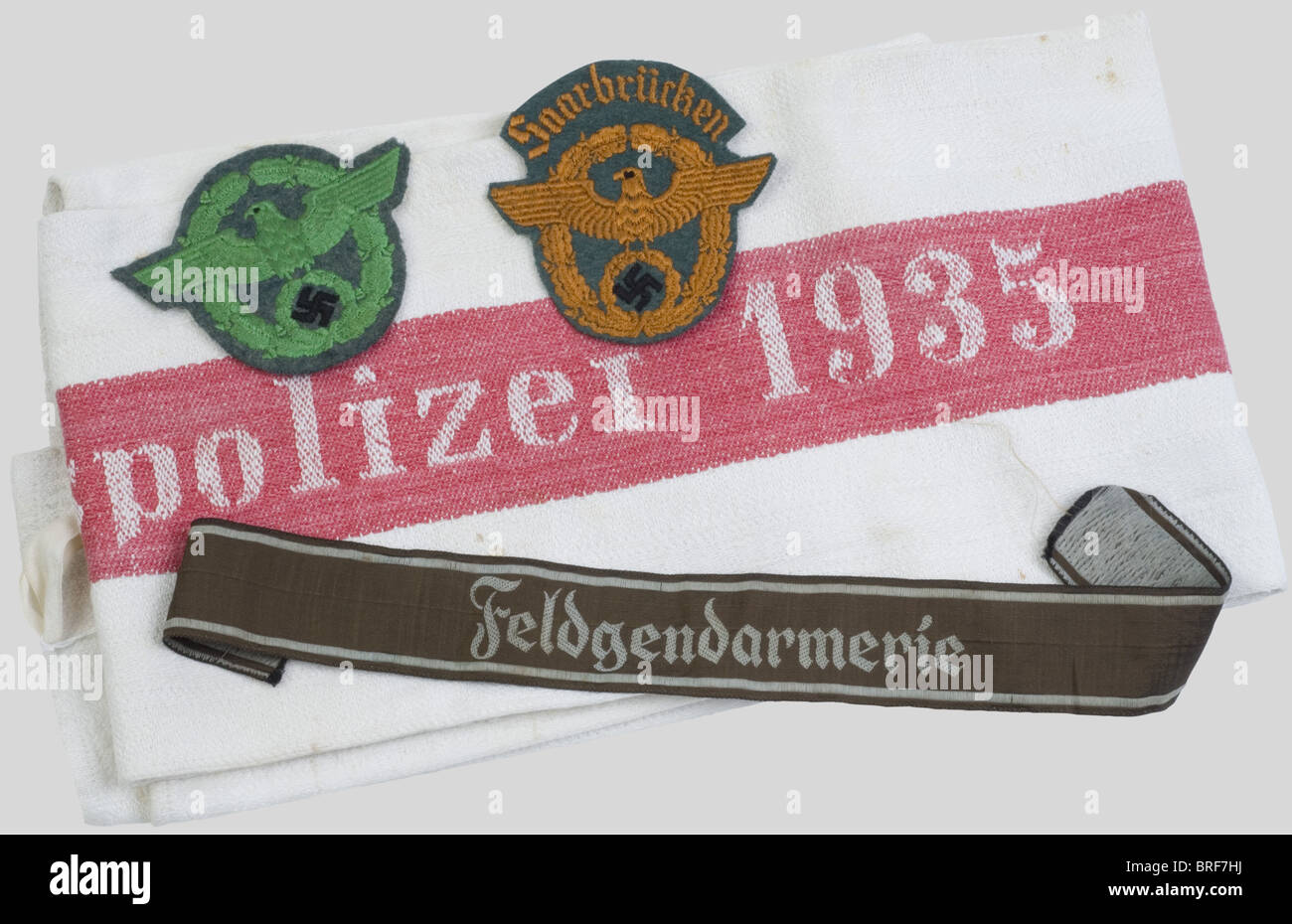 A group of Police uniform items, including a BEVO 'Feldgendarmerie' cufftitle, a Saarbrücken Gendarmerie arm eagle, a Schutzpolizei arm eagle, a Police mess cloth., historic, historical, 1930s, 1930s, 20th century, utensil, piece of equipment, utensils, item, items, Stock Photo
