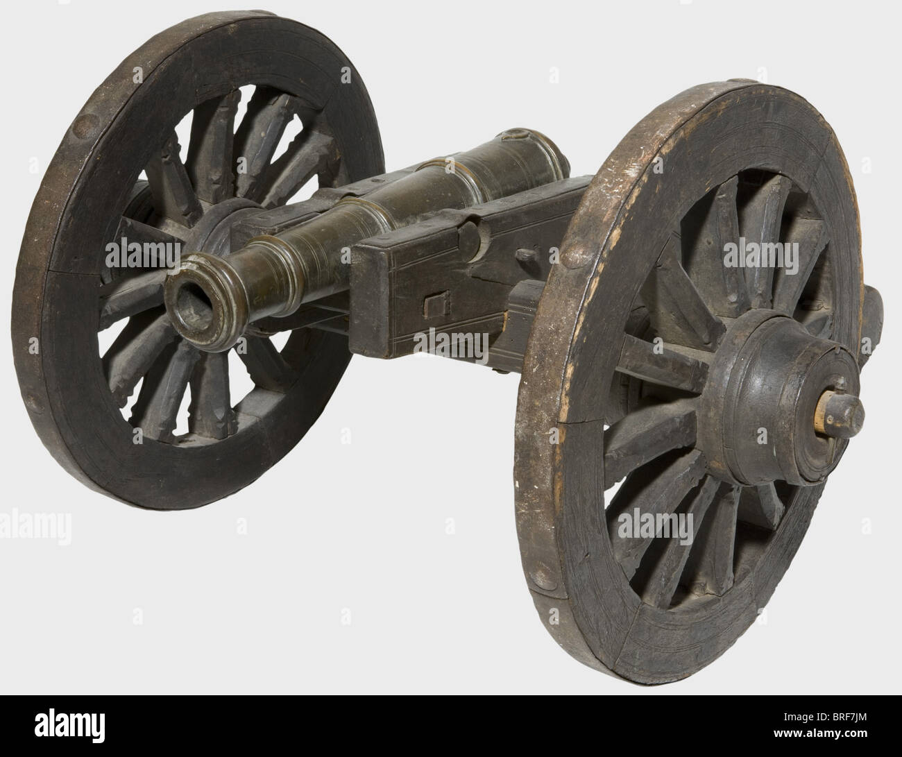 A model of a field cannon, 17th/18th century. Slender bronze barrel in 27 mm calibre with a cannon muzzle, two side-mounted trunnions, and a touchhole in a heart-shaped depression on top. Wooden carriage (some worm damage) with iron fittings and iron mounted wheels with spokes. Barrel length 39 cm. Total length 78 cm. historic, historical,, 18th century, 17th century, cannon, cannons, artillery, firearm, fire arm, firearms, fire arms, weapons, arms, weapon, arm, fighting device, military, militaria, object, objects, stills, clipping, clippings, cut out, cut-out, Stock Photo