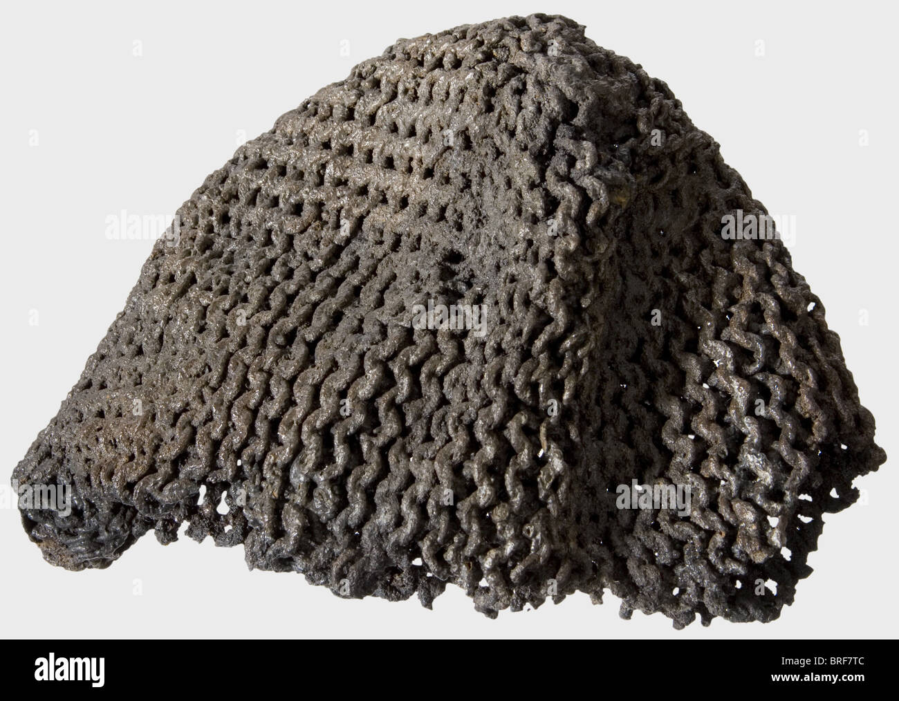 A Mongolian helmet and chain mail coif, Period of the Golden Horde, 14th century,. Made of four embossed, overlapping iron segments riveted together. Obvious damage, especially on the lower rim, and the riveting is loose at the top. Otherwise the metal is quite well preserved. Height 17 cm. Weight 615 g. Conserved condition as discovered. It comes with a fragment of an iron mail coif, solidified with corrosion, cleaned, and conserved. Height 17 cm. Weight 818 g. Cf. two Mongolian helmets of identical provenance: Hermann Historica, auction 49, 19 October 2005, l, Stock Photo