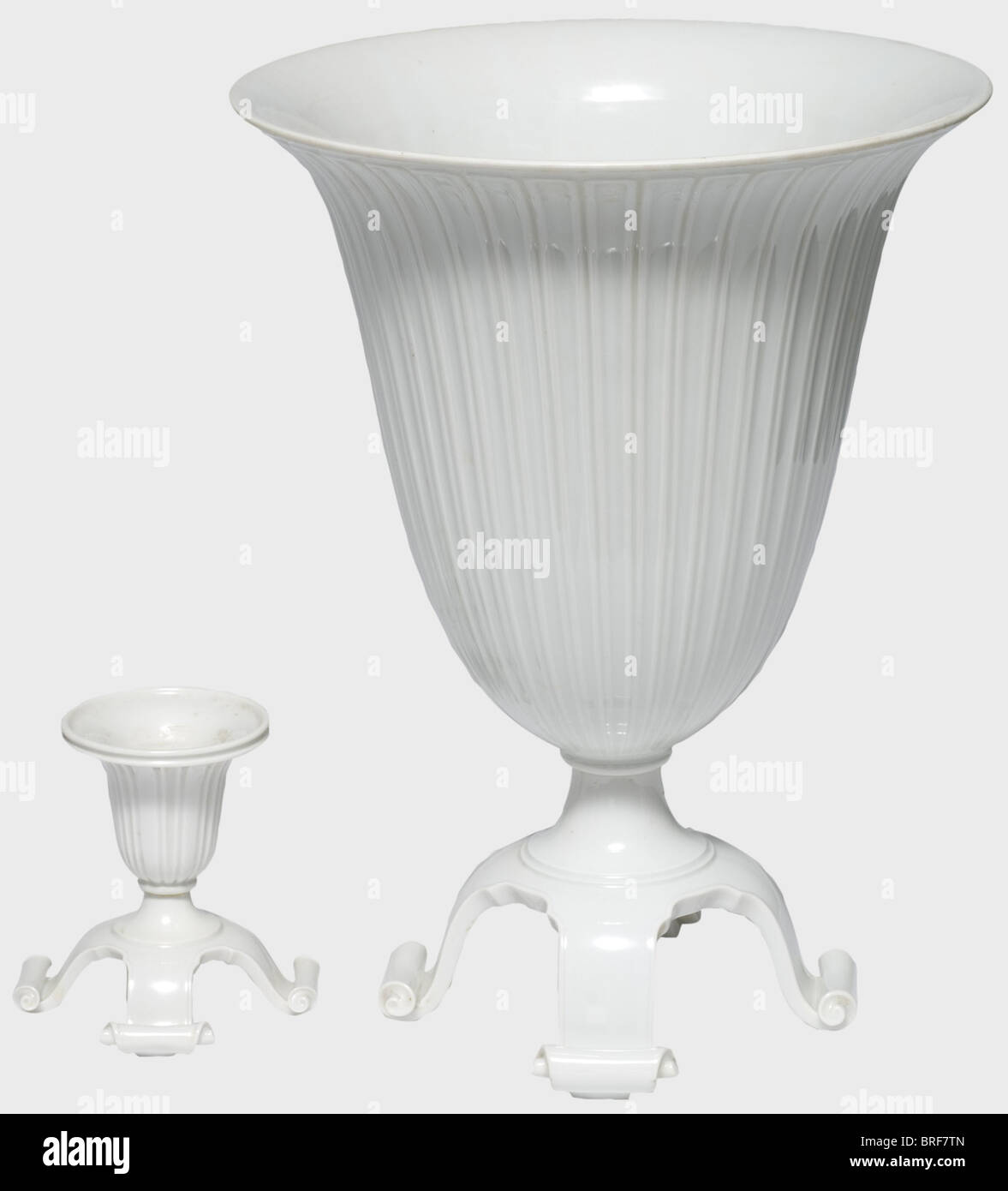 A krater vase and a candel holder, designed by Adolf Röhring. White glazed porcelain, the sides with ribbed decoration. Four curved feet with the ends rolled inward. Manufacturer's pressmark, artist's signature 'Röhring', and the model number '515' are on the bottom. Height 33 cm. Includes the candel holder of the same shape and style, with the pressmark and artist's signature on the bottom, but no model number. Height 10.8 cm. Undamaged, extremely rare, not in the 1938/39 factory catalogue. Cf. Hermann Historica, 46th auction, 7/8May 2004, lot 5703. historic, , Stock Photo