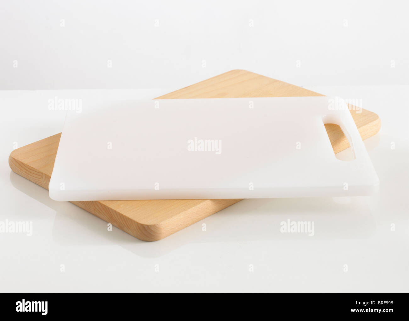 Wooden and white chopping board against white background Stock Photo