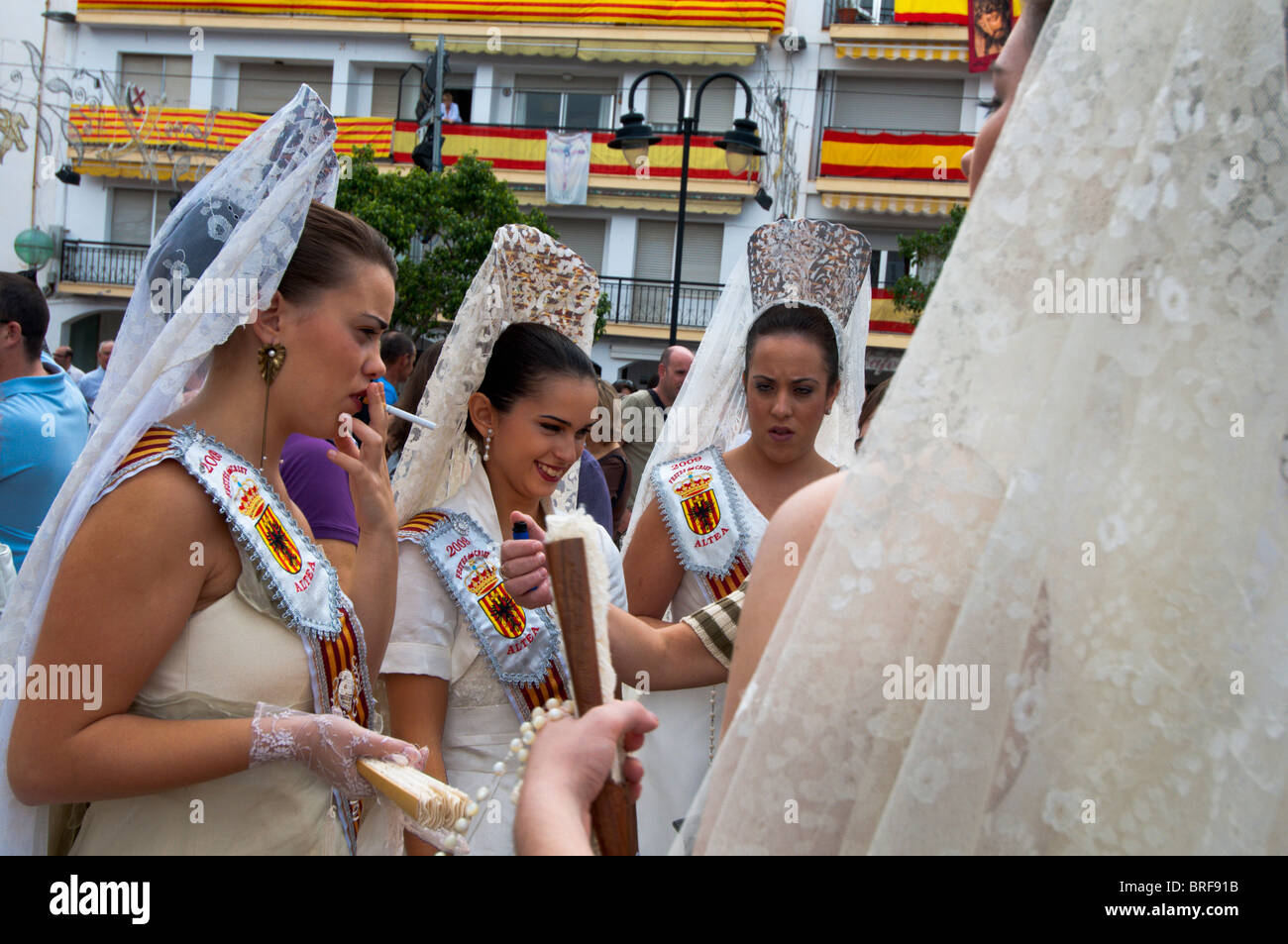 Fiesta queen and her maids take a cigarette break during the  Moors and Christians fiesta. Stock Photo