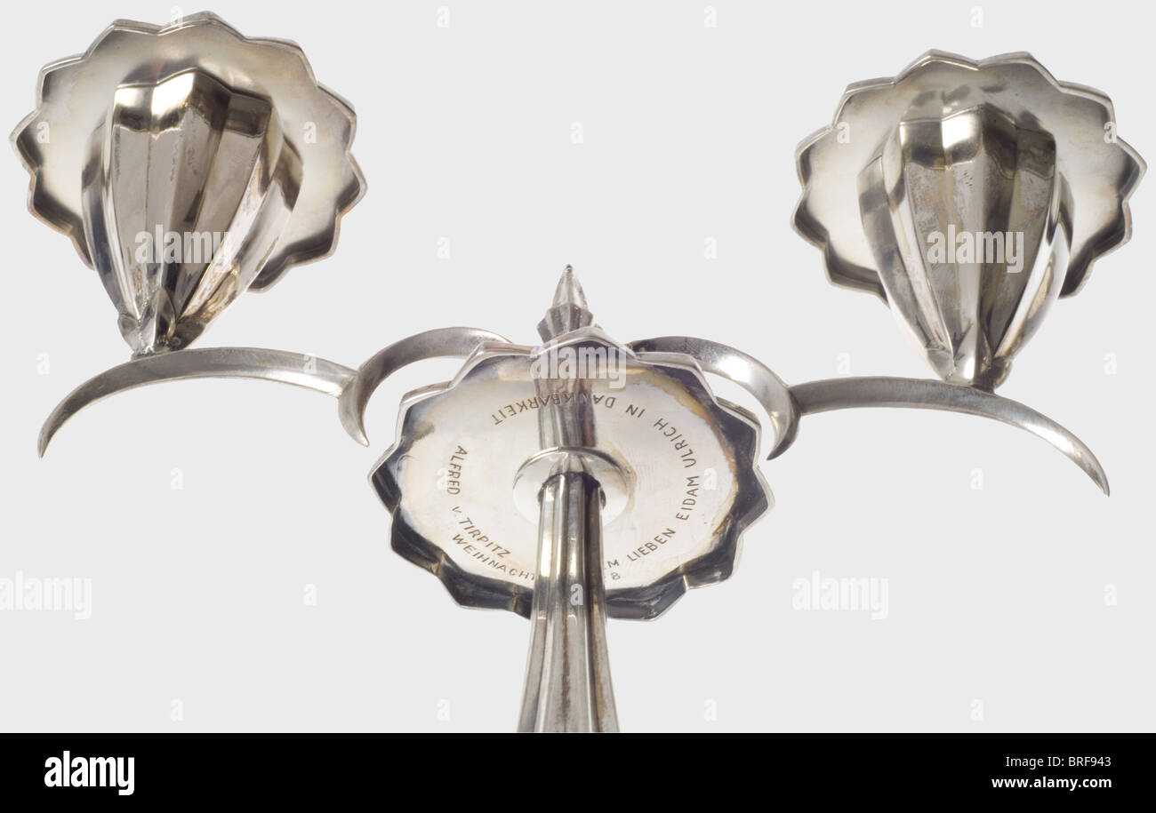 Ulrich von Hassell - a pair of silver candelabra, presented to him by his father-in-law, Grand Admiral von Tirpitz, 1928. Fluted, two-light candelabra with central spike (probably for a third candle) and blossom-shaped drip pans. The middle pan engraved on the lower side with the inscription (transl.) 'To his dear son-in-law Ulrich, in appreciation, Alfred von Tirpitz - Christmas 1928'. The foot with integral weight and green protective felt cover on the base. German hallmark '800', illegible master's signature. Height 22 and 22.5 cm. In hard times a sign of gr, Stock Photo