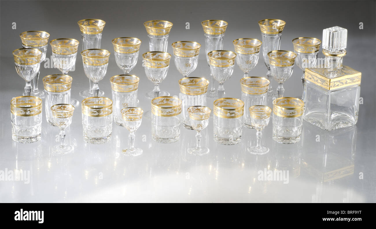 Erich Honecker (1912 - 1994) - a 32 piece set of glasses, for the Chairman of the East German Government (1976 - 1989). Lead crystal, Josephinenhütte glass cut with prisms on the sides and a star on the base. Open work golden friezes bearing stag hunting scenes, below the rims. Each glass has an etched or gilded, 'EH' monogram. The set consists of four champagne glasses (height 20.5 cm), six red wine glasses (height 17 cm), six white wine glasses (height 16.5 cm) four water glasses (height 12 cm.), five whiskey glasses (height 9.5 cm), six liqueur glasses (heig, Stock Photo