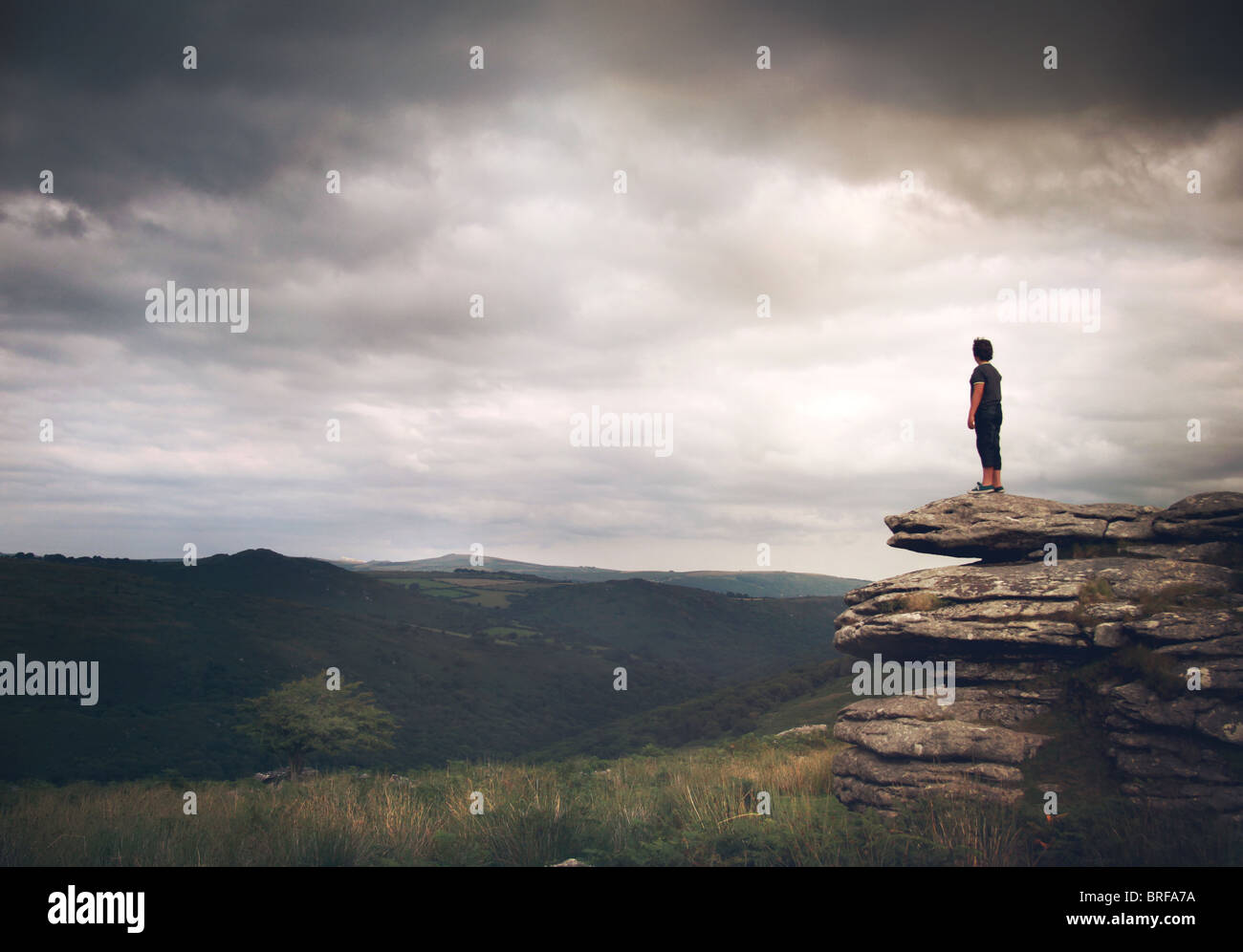 boy stood on the rocks looking over moors Stock Photo