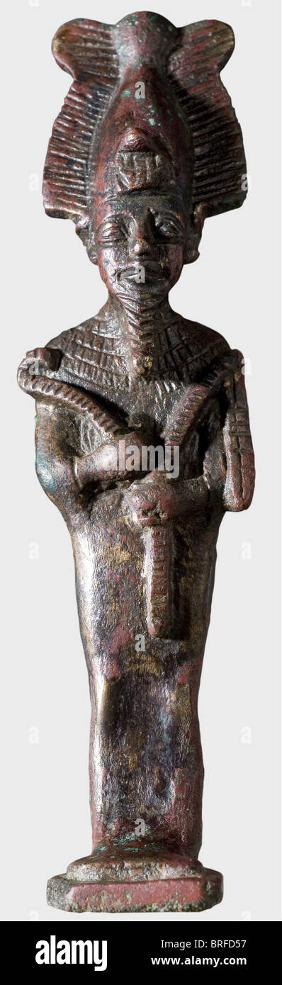 An Egyptian statuette of Orisis, late Ptolemaic to Roman period. Full cast bronze with greenish-red patina. Sculpted figure in relief wearing the Atef Crown and holding the royal insignia, the crook and flail, in front of the chest. In beautiful condition except for the damaged loop on the back. Height 10.4 cm. historic, historical, people, ancient world, Mesopotamia, Mesopotamian, Middle East, Middle-East, exotic, statuette, figurine, figurines, statuettes, sculpture, sculptures, fine arts, art, object, objects, stills, clipping, clippings, cut out, cut-out, c, Stock Photo
