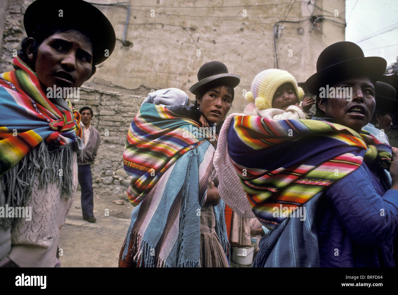 Aymara indian mothers carry their baby children on their backs, Llallagua mining town, Bolivia Stock Photo