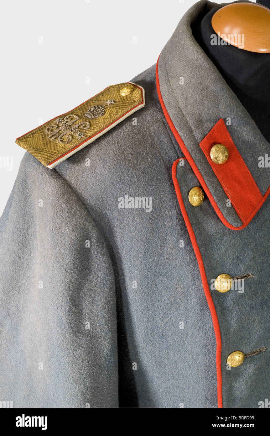 A Major General's coat., A long coat of coarse grey green twill with red piping and red silk lining. Gilded brass buttons (two replaced) displaying the Russian double eagle. Manufacturer 'Kopejkin'. A stamp of a russian theater magazine on the inside of the lining of one sleeve. Sewn-on shoulder boards (fastening straps are replaced) displaying the cipher 'N II' embroidered in silver beneath the Russian imperial crown. historic, historical, 19th century, uniform, uniforms, clothes, outfit, outfits, wear, textile, Stock Photo