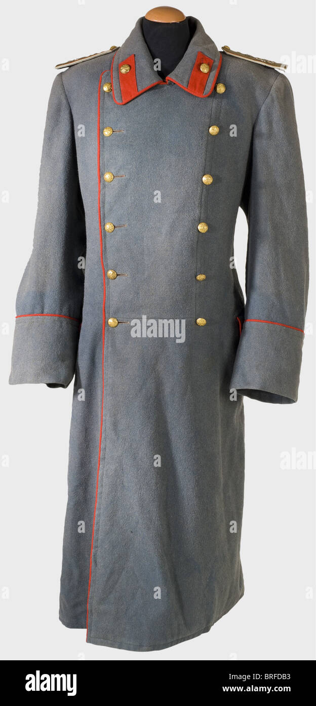 A Major General's coat., A long coat of coarse grey green twill with red piping and red silk lining. Gilded brass buttons (two replaced) displaying the Russian double eagle. Manufacturer 'Kopejkin'. A stamp of a russian theater magazine on the inside of the lining of one sleeve. Sewn-on shoulder boards (fastening straps are replaced) displaying the cipher 'N II' embroidered in silver beneath the Russian imperial crown. historic, historical, 19th century, uniform, uniforms, clothes, outfit, outfits, wear, textile, object, objects, stills, clipping, clippings, cu, Stock Photo